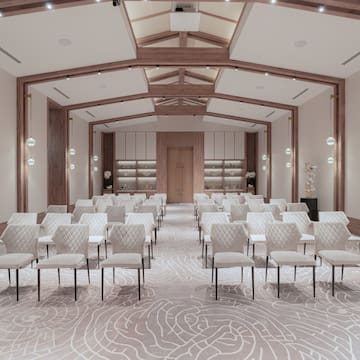 a room with white chairs and a light colored carpet