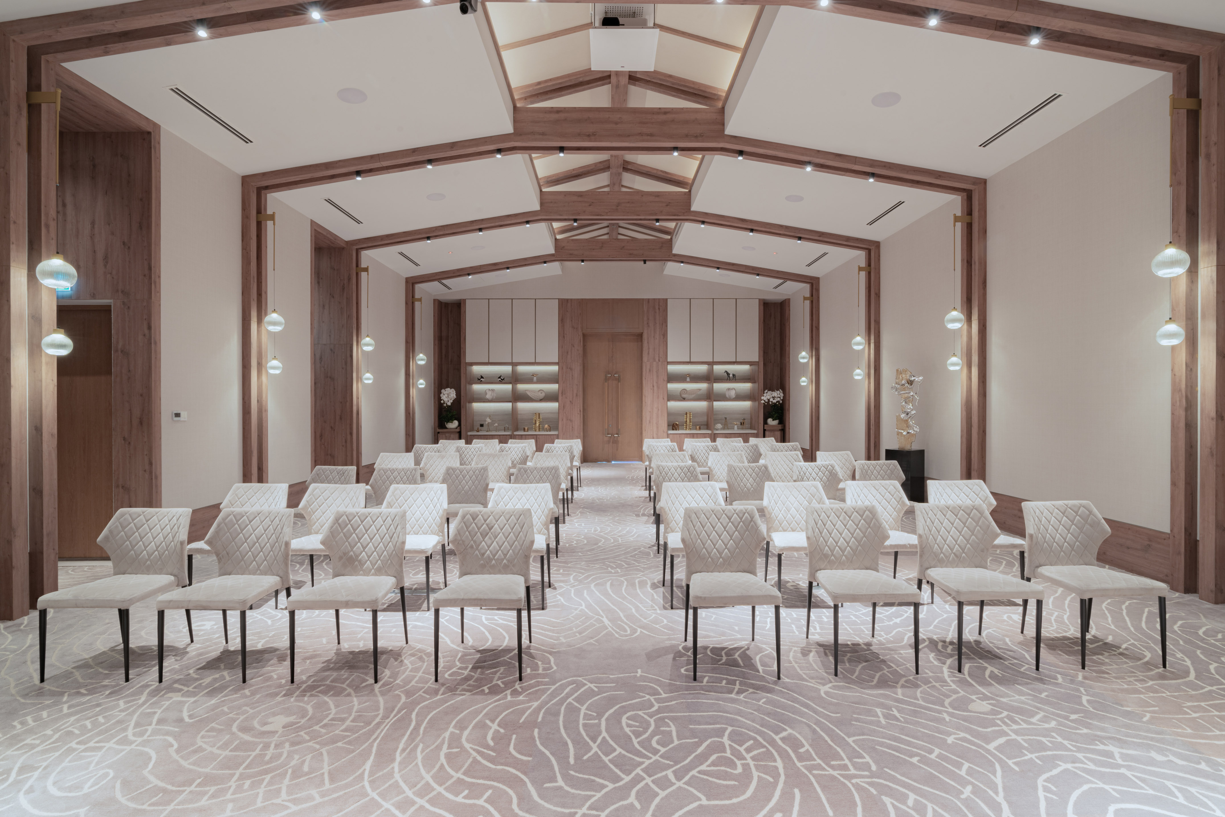 a room with white chairs and a light colored carpet