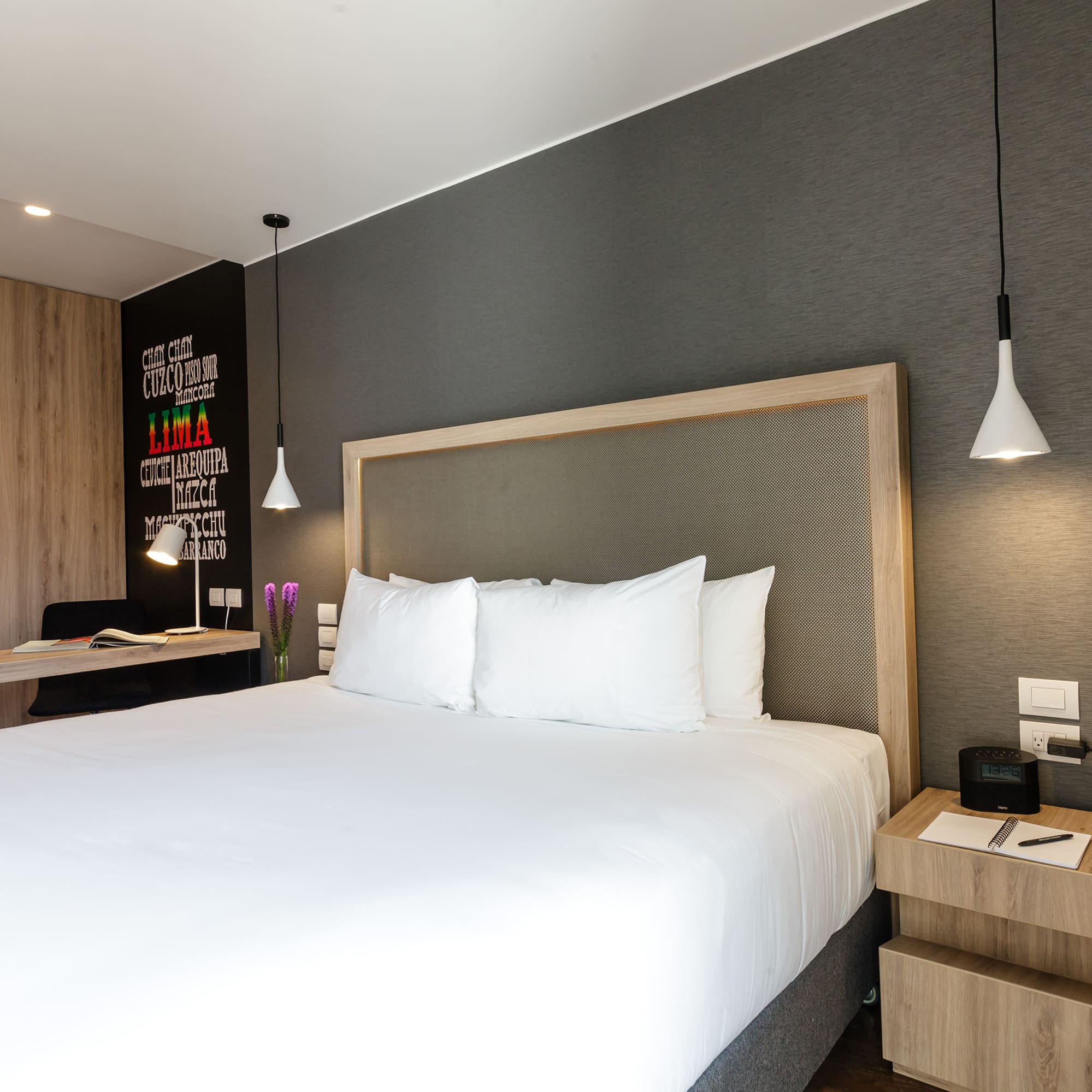 a bed with white sheets and a wood headboard