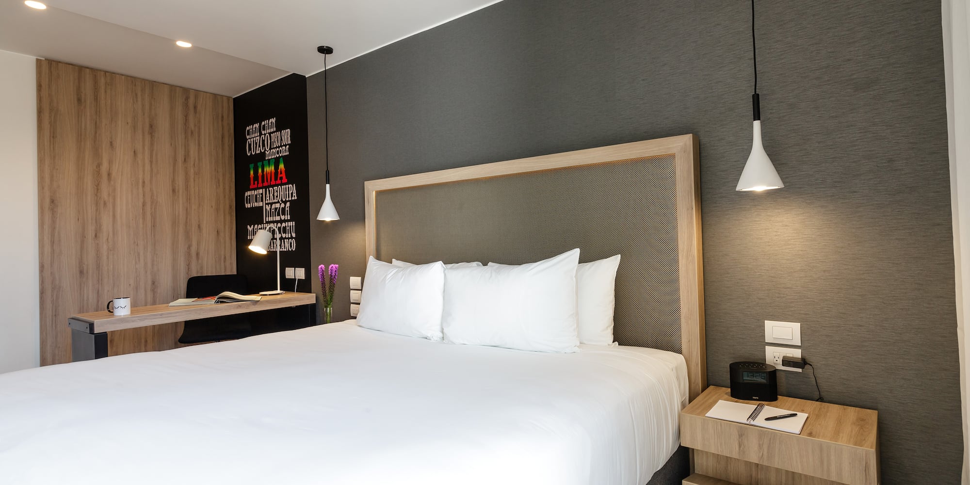 a bed with white sheets and a wood headboard