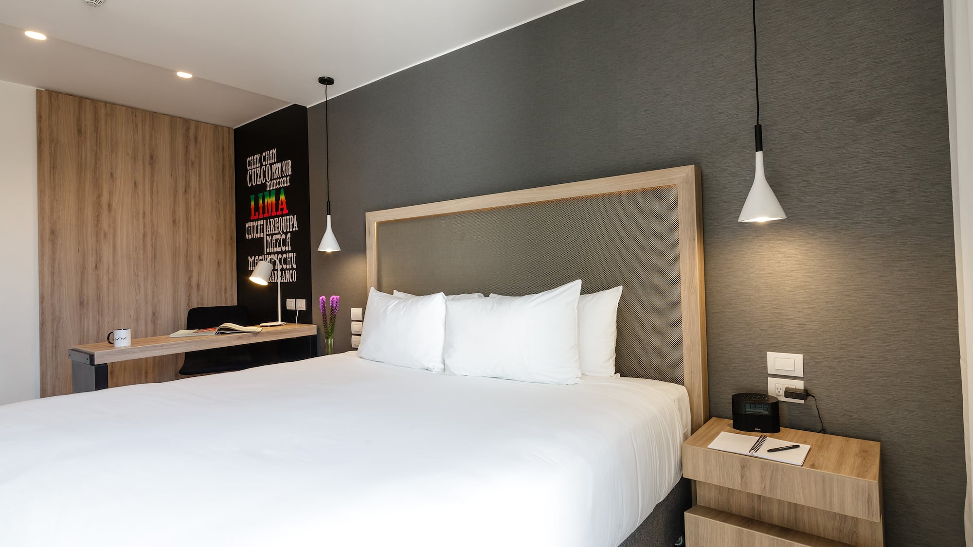 a bed with white sheets and a wood headboard