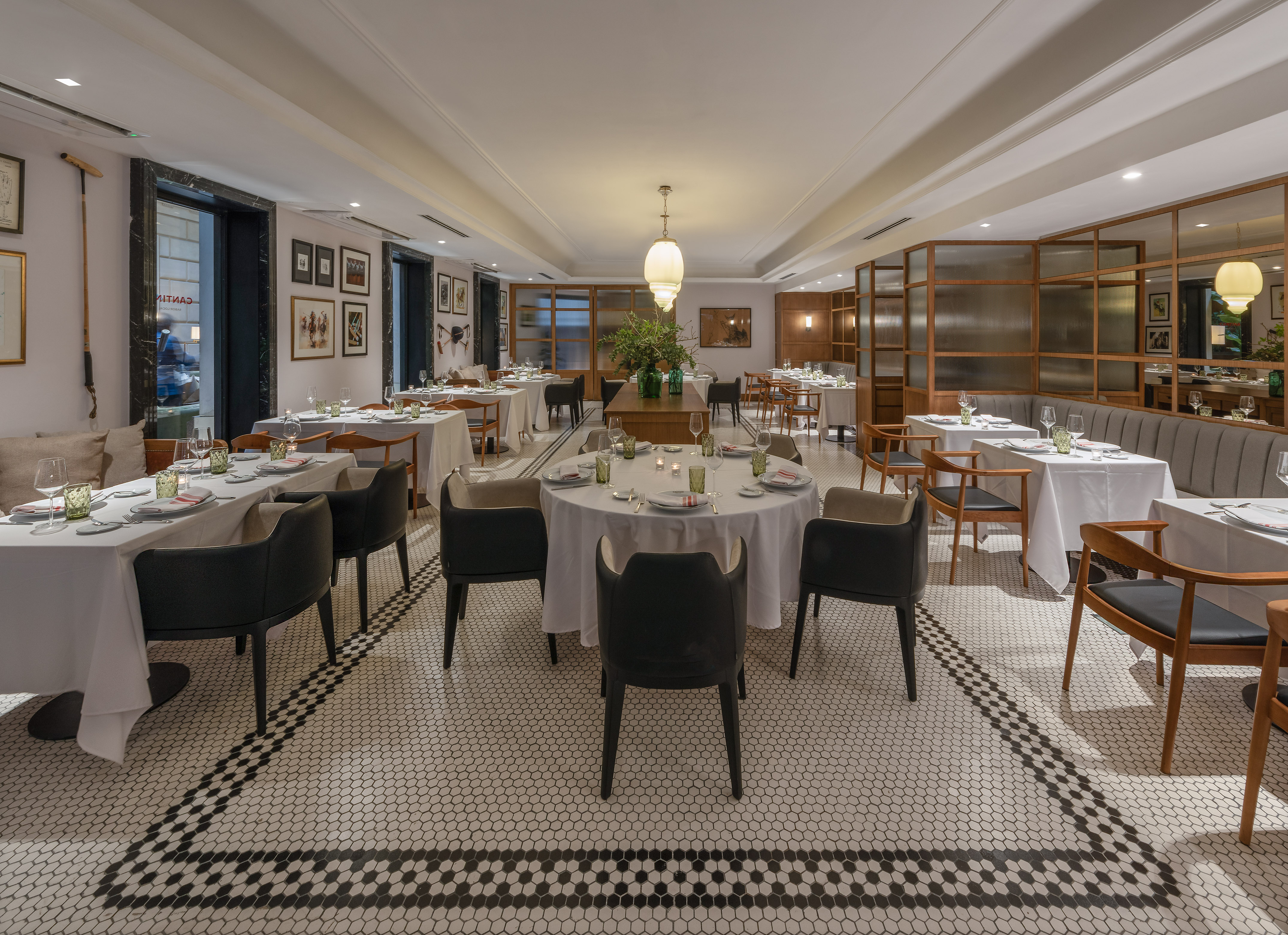 Elegant restaurant with set tables, black & white hexagonal mosaic floor.