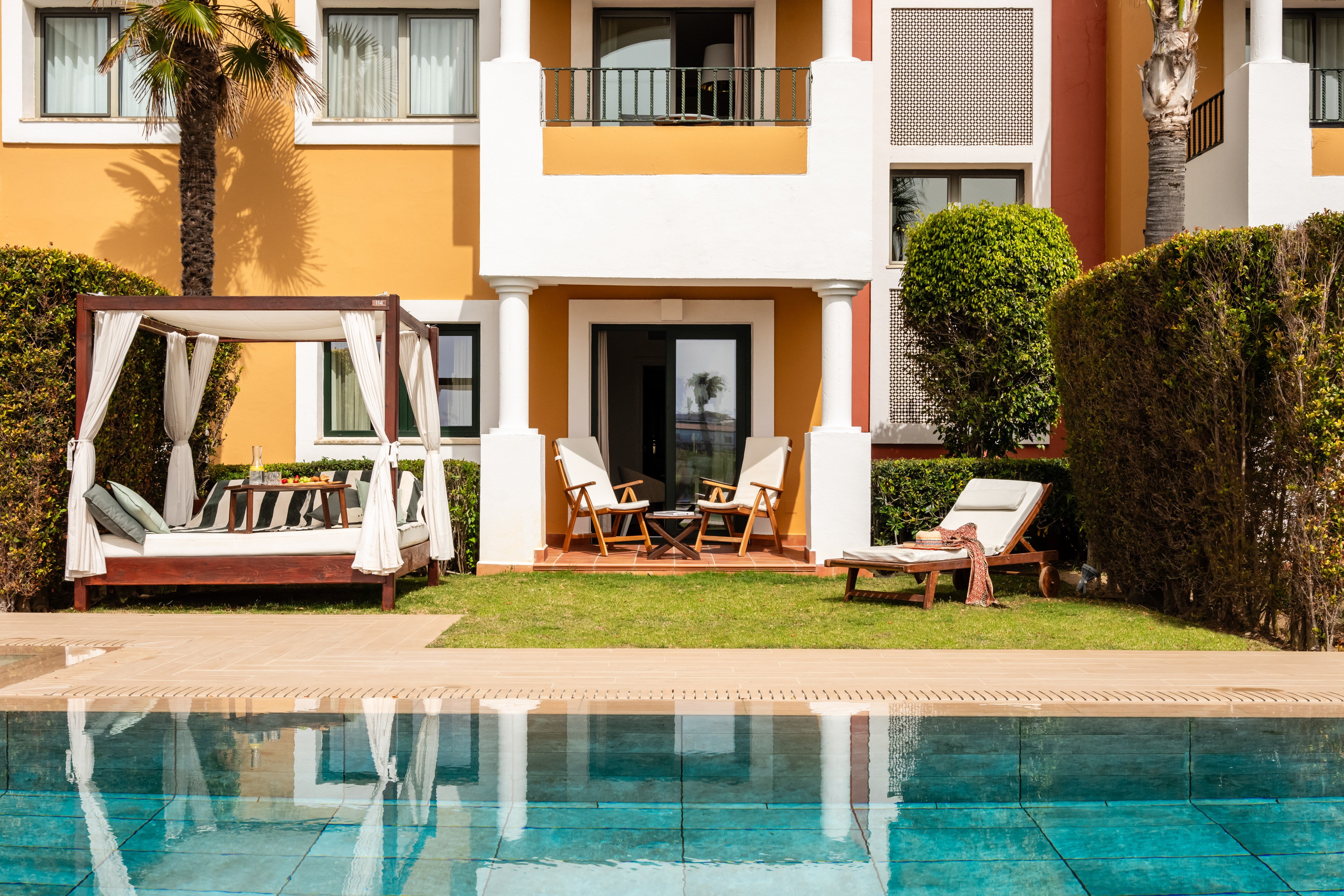 Luxury hotel resort with pool, outdoor cabana, and patio.