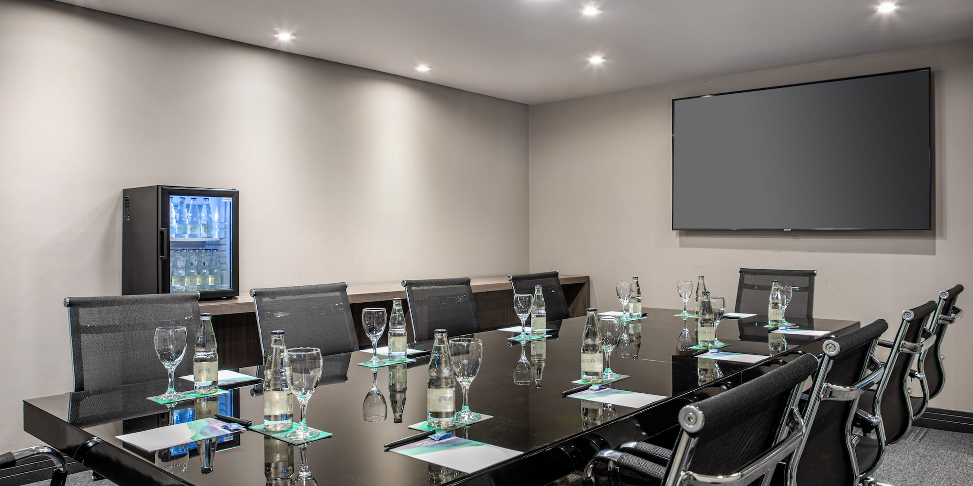 a conference room with a black table and chairs