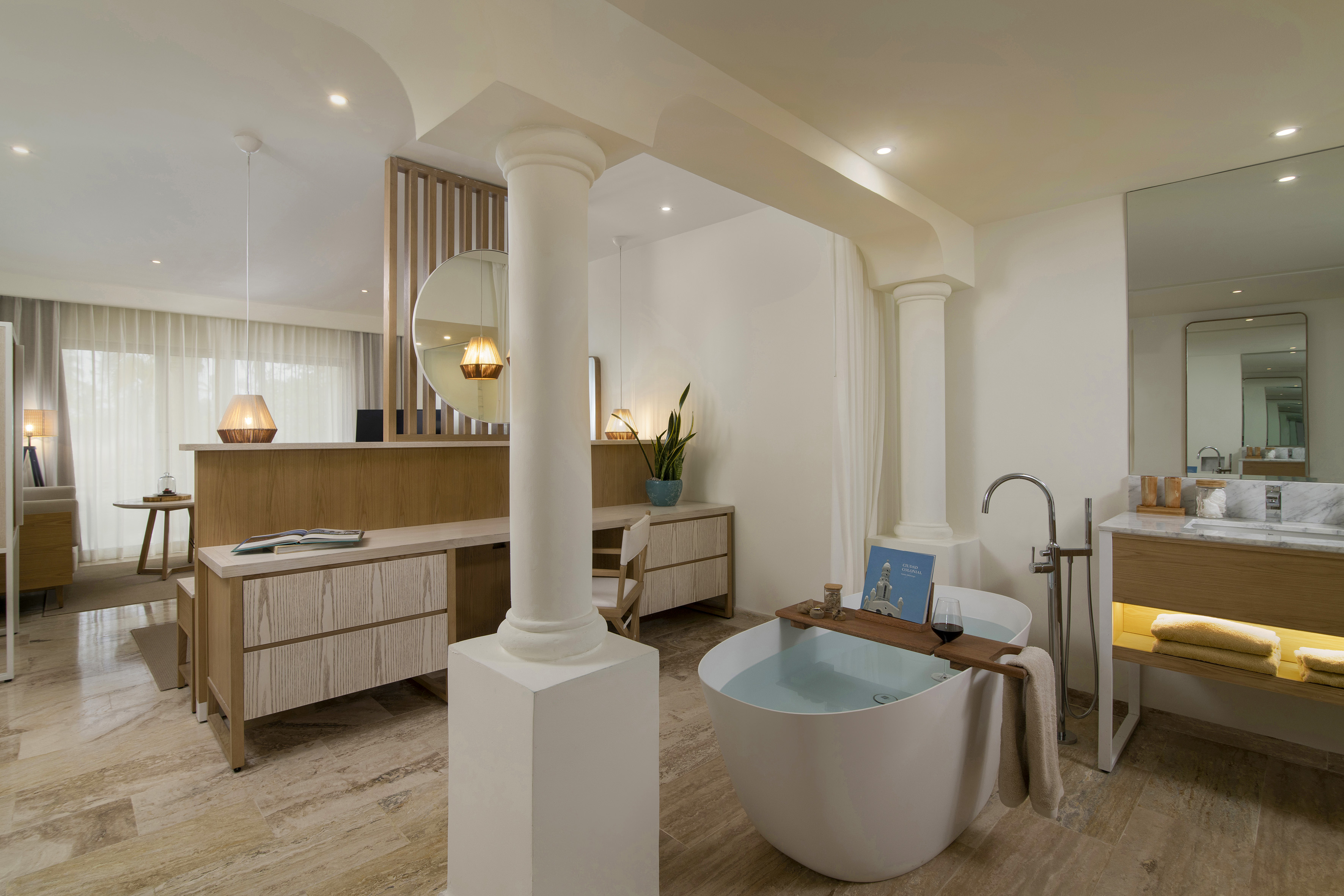 Modern luxury bathroom with freestanding tub, wood vanity, and open design.