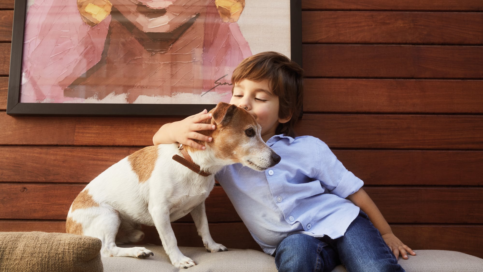 a boy kissing a dog