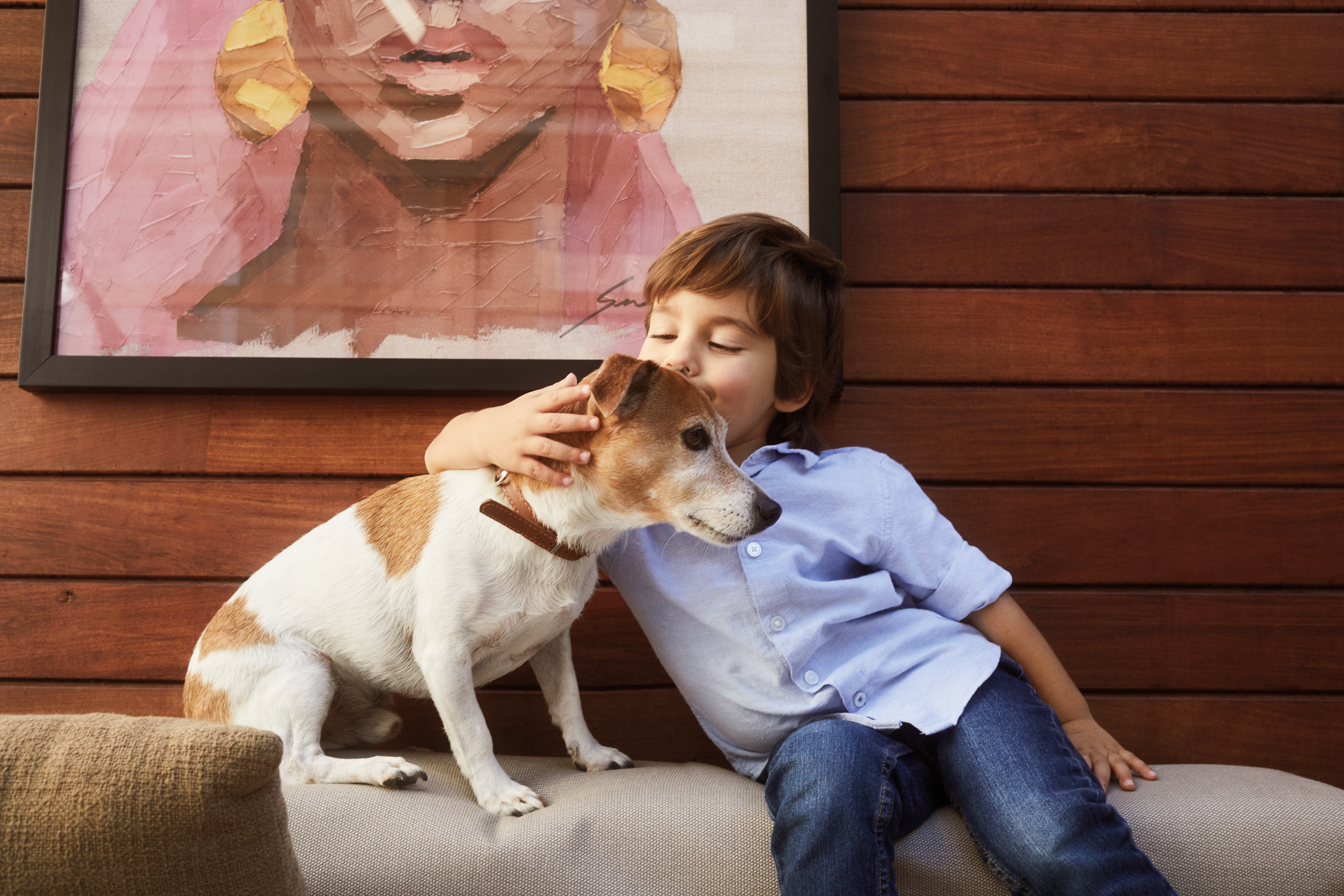 a boy kissing a dog