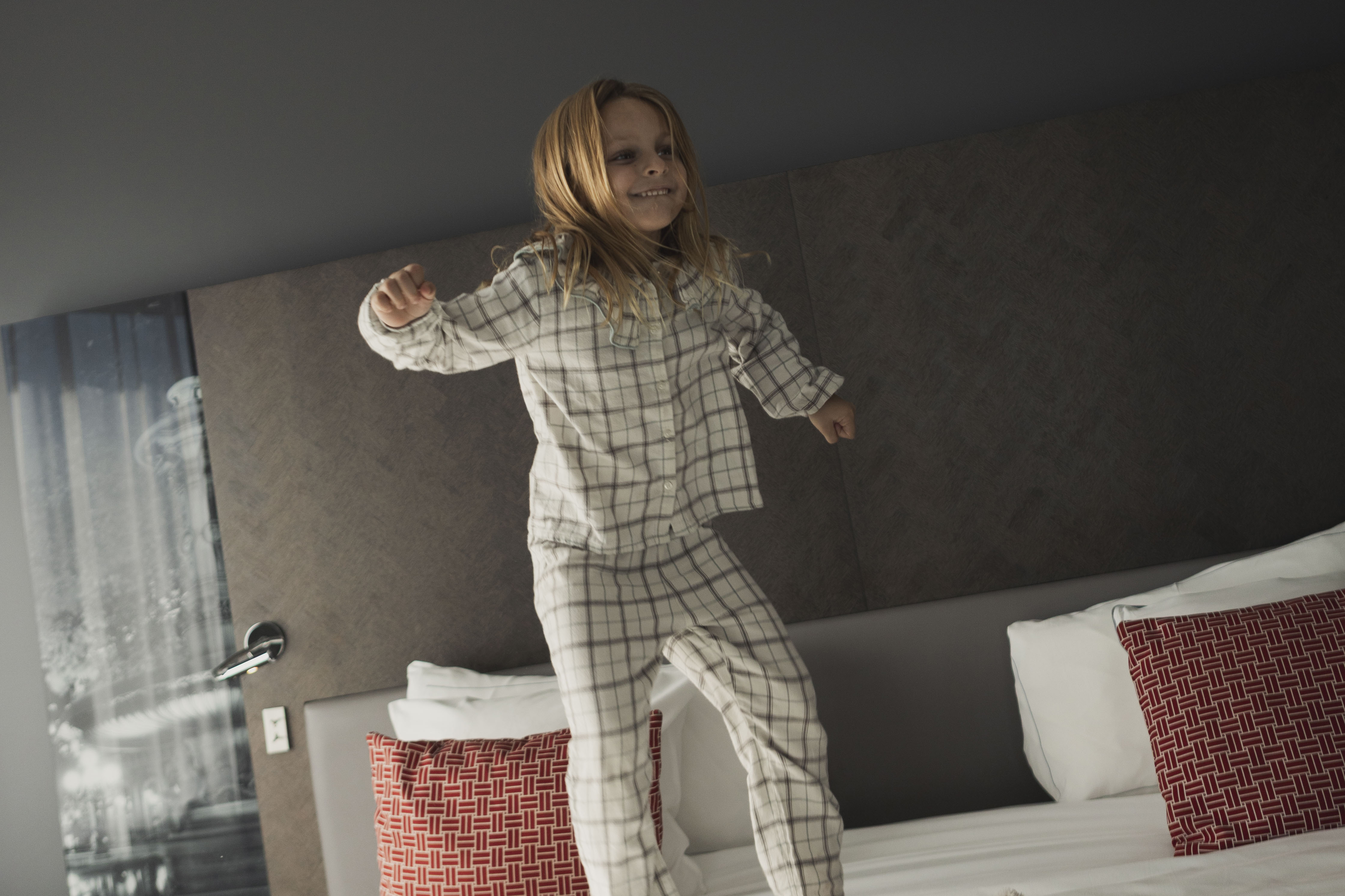 a girl jumping on a bed