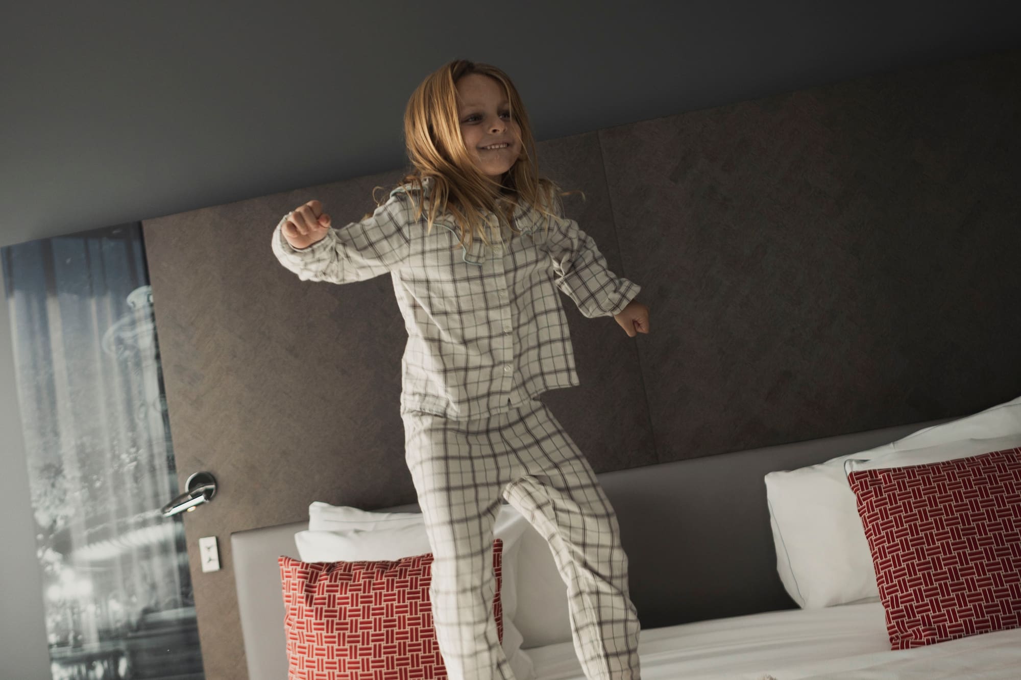 a girl jumping on a bed