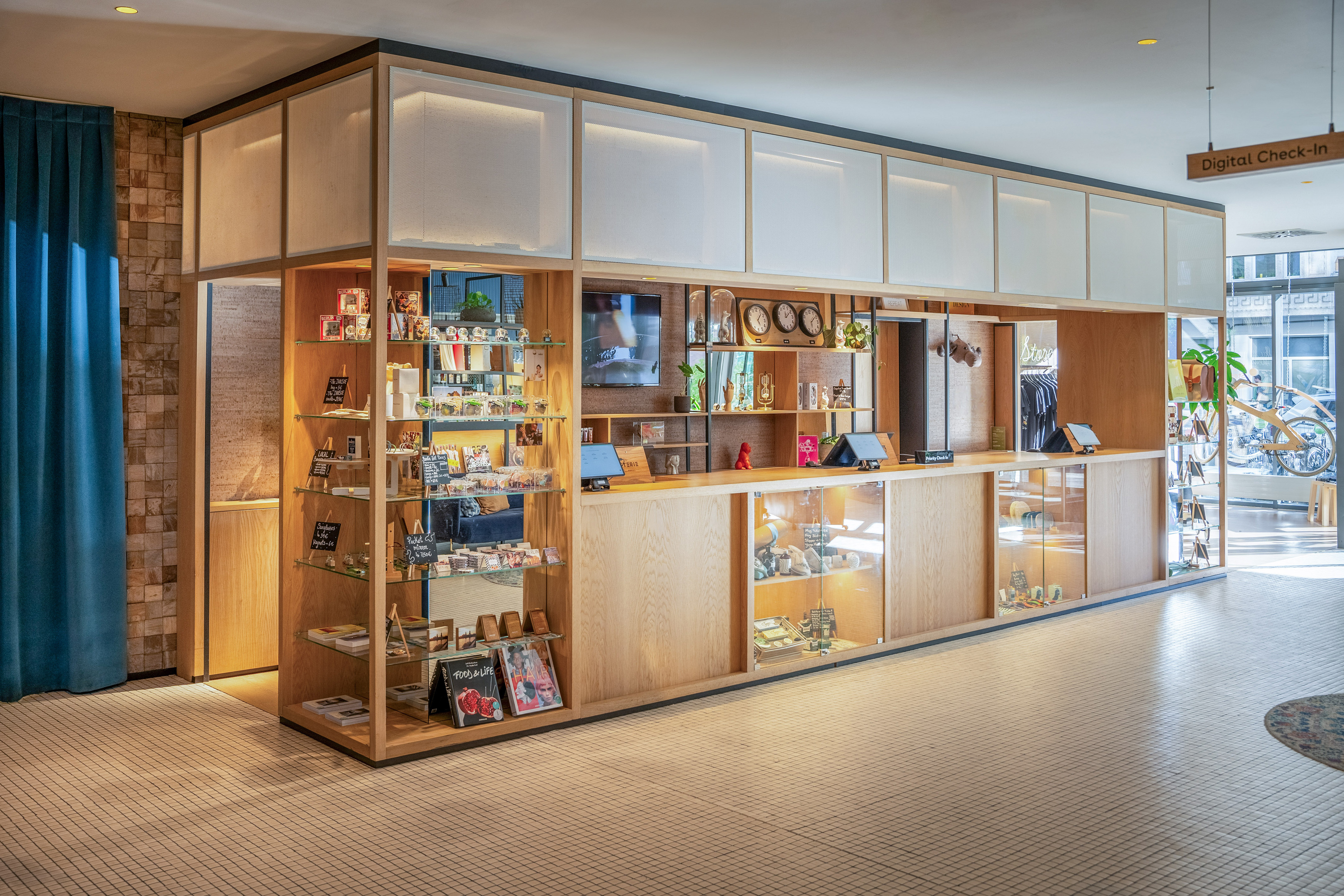 Modern hotel reception with wooden retail counter and digital check-in.
