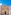 Maltese Baroque church with white saint statues against a blue sky.