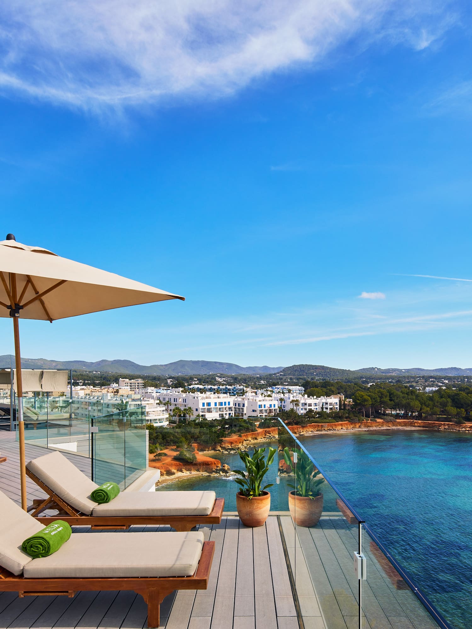 a deck with chairs and umbrellas overlooking a body of water