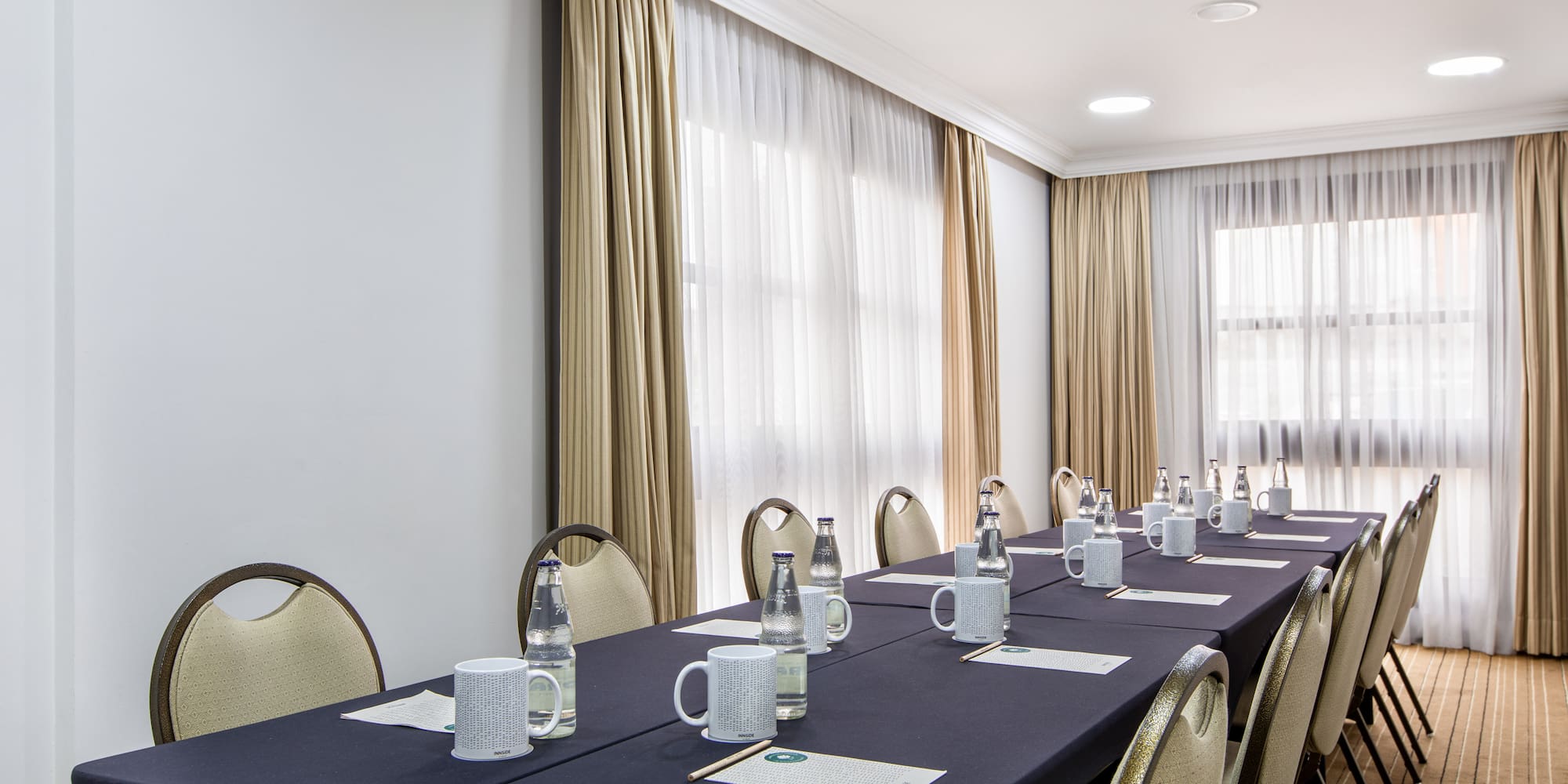 a long table with cups and papers on it