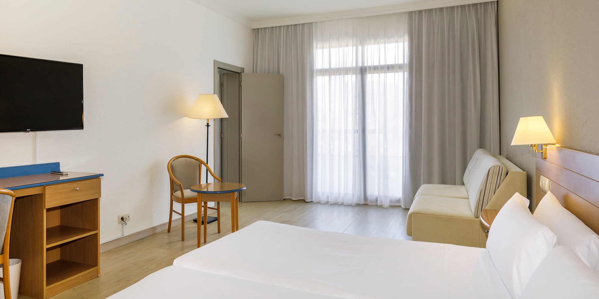 a room with two beds and a desk and a chair