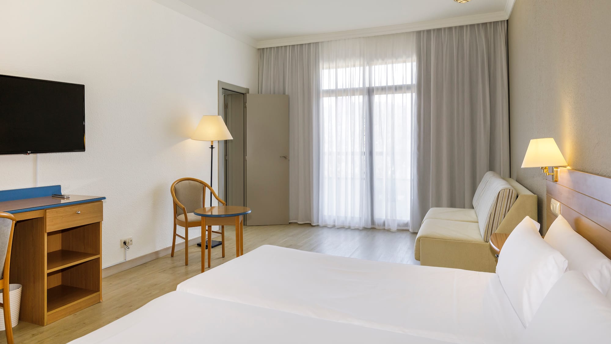 a room with two beds and a desk and a chair