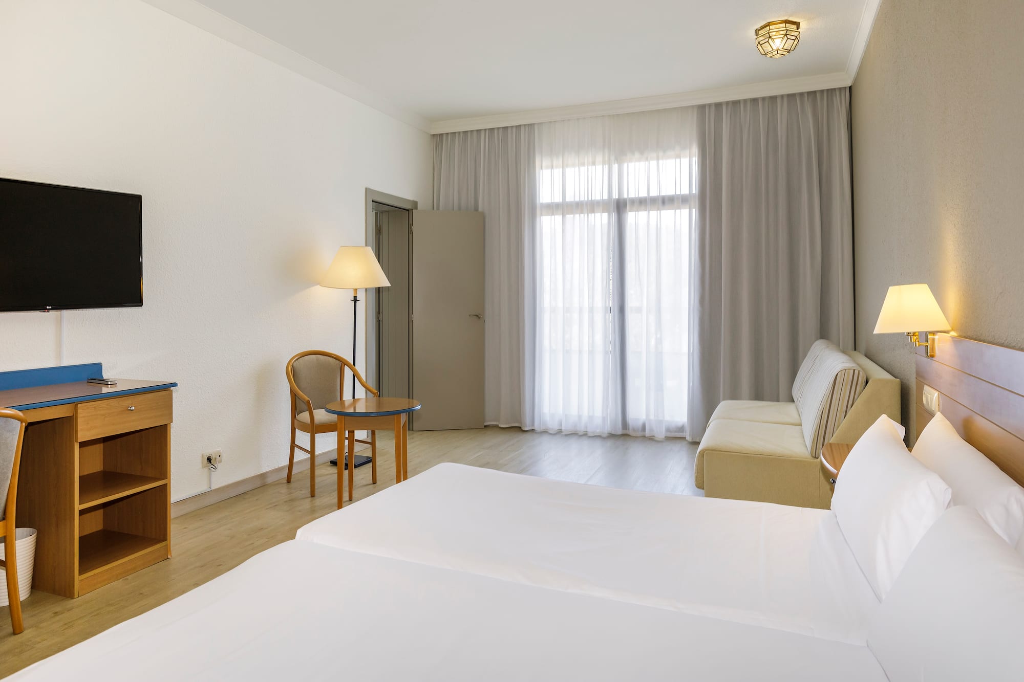 a room with two beds and a desk and a chair