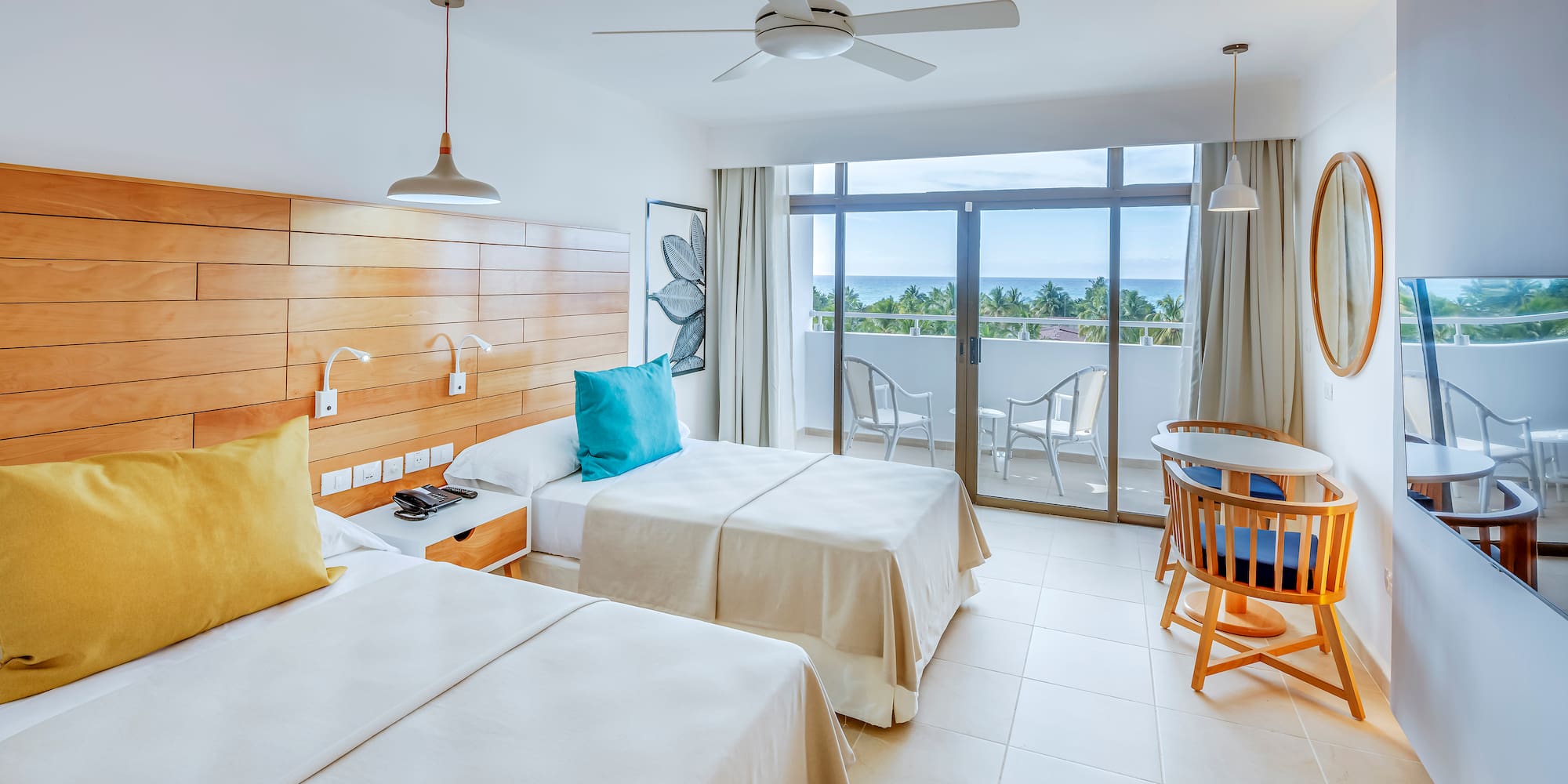 a room with two beds and a table and chairs