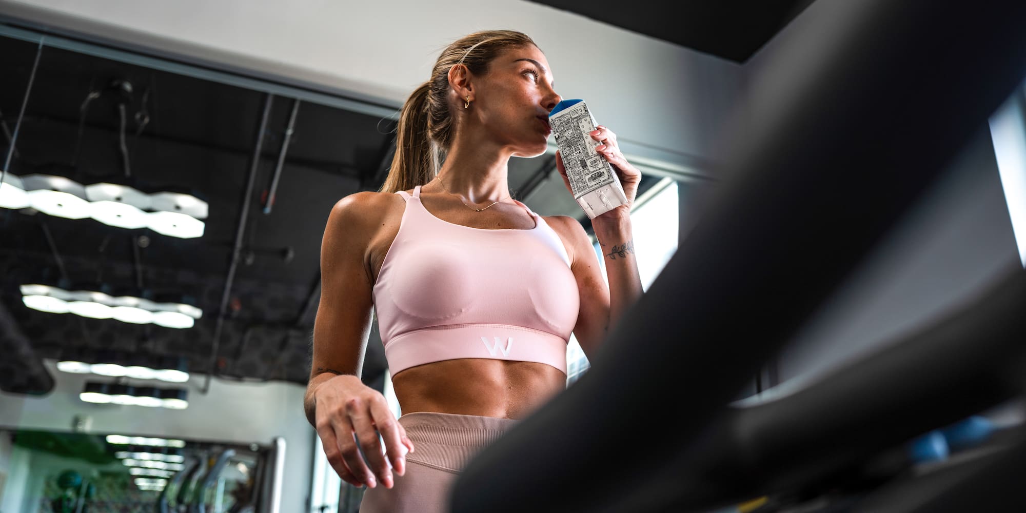 Woman in activewear hydrating during a gym workout.