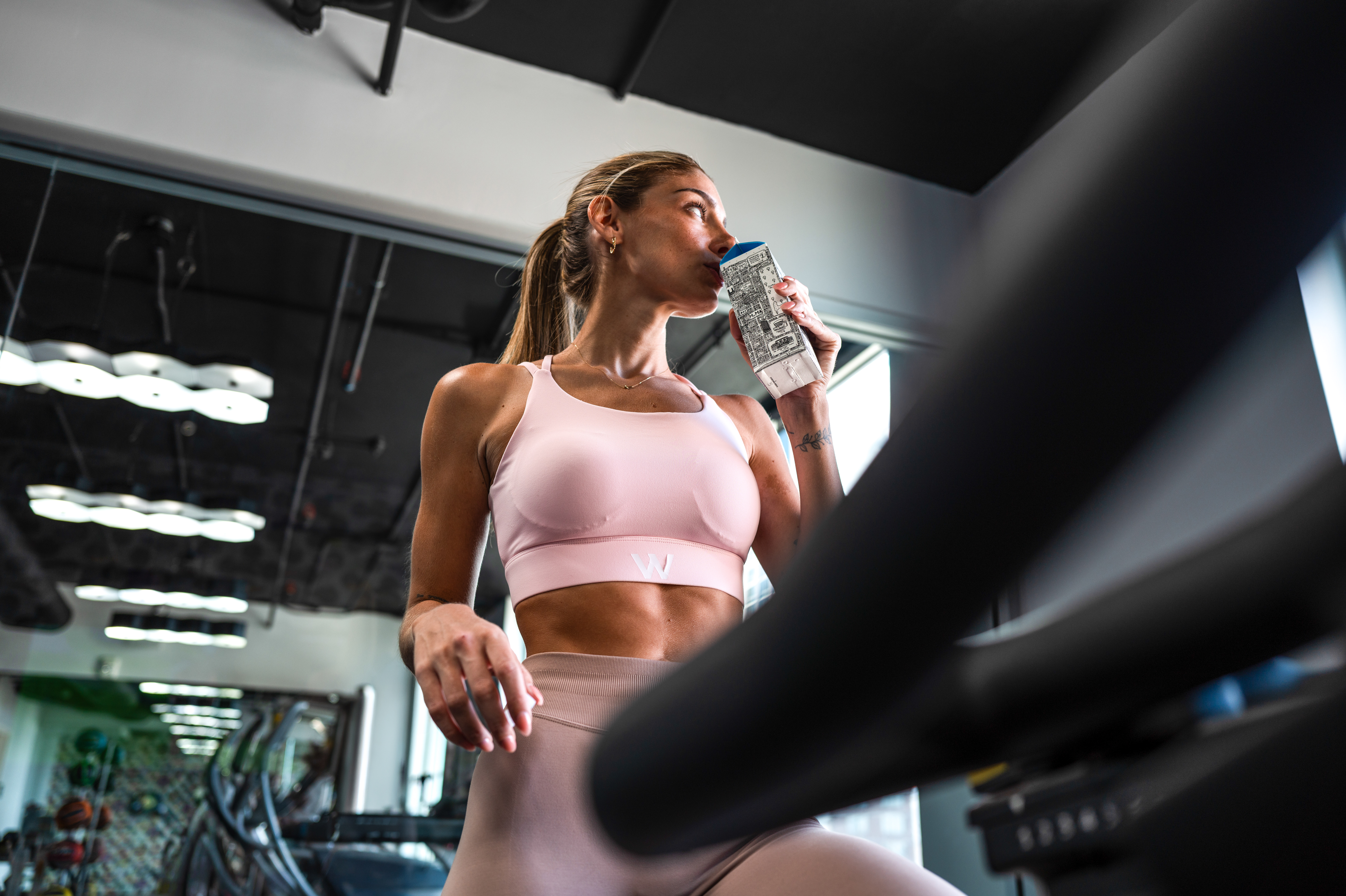 Woman in activewear hydrating during a gym workout.