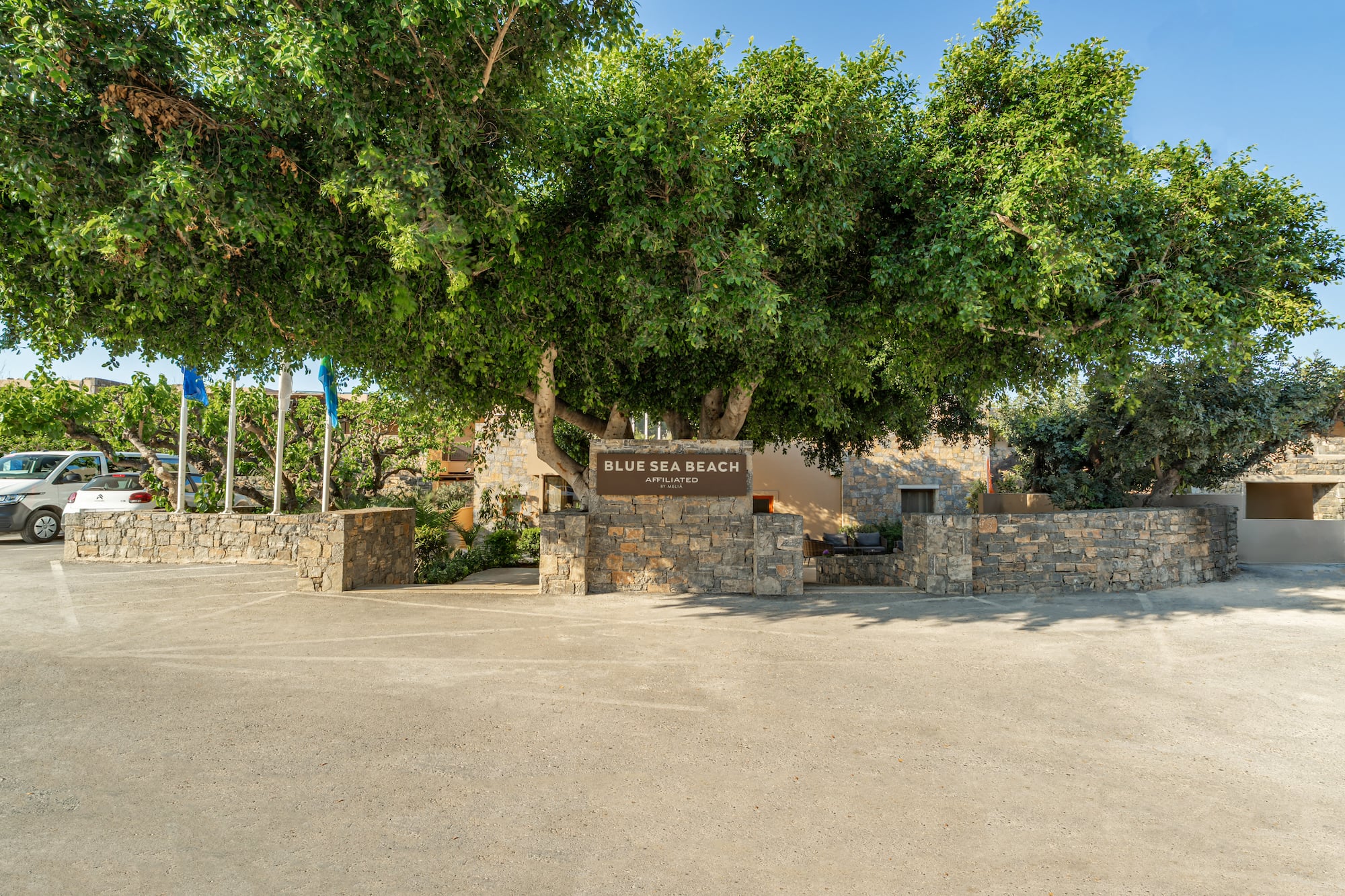 Blue Sea Beach Melia entrance sign with large tree and parking.