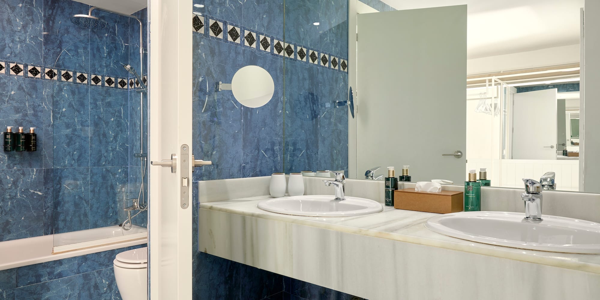 a bathroom with blue tile walls and sinks