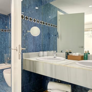 a bathroom with blue tile walls and sinks