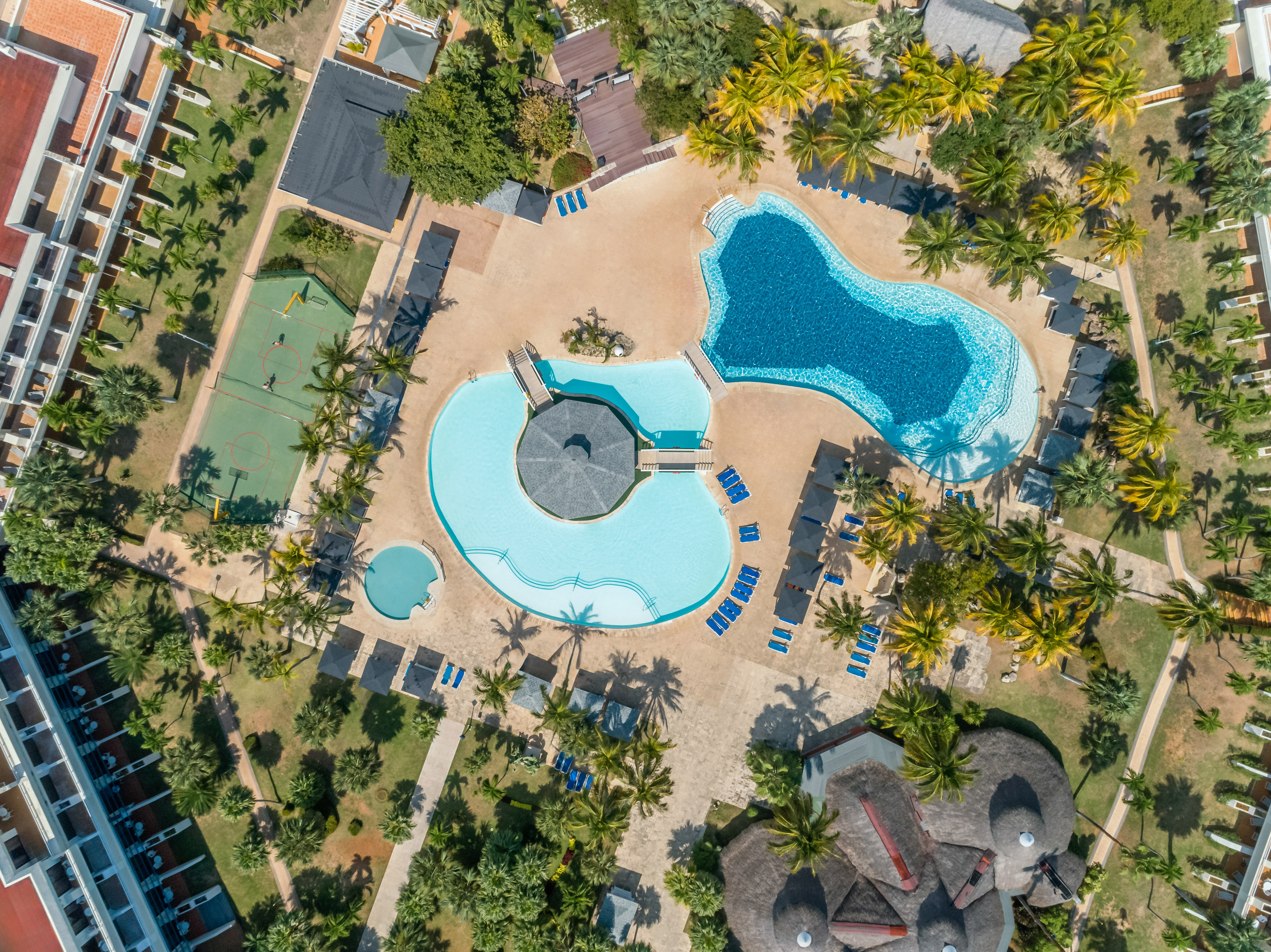 an aerial view of a resort with a pool and palm trees
