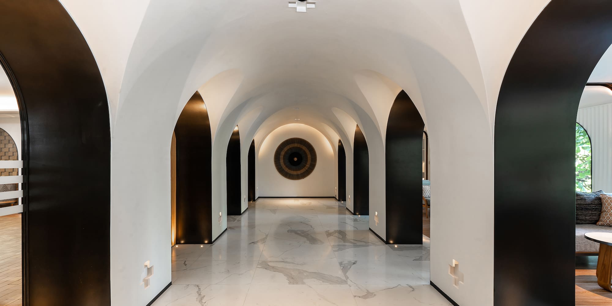 a hallway with arched walls and black and white walls