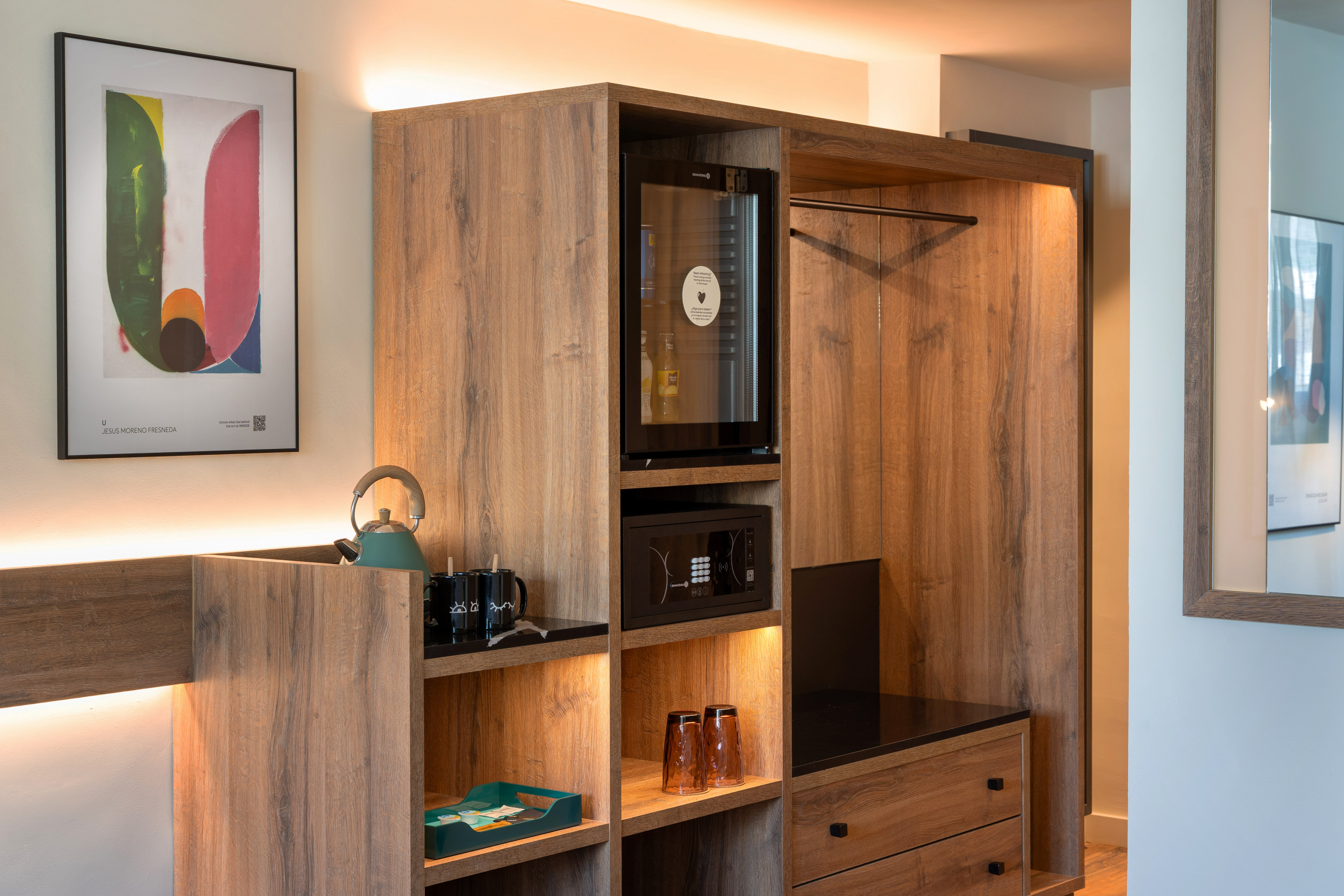 Hotel room amenities: wooden cabinet, minibar, safe, kettle, wardrobe.