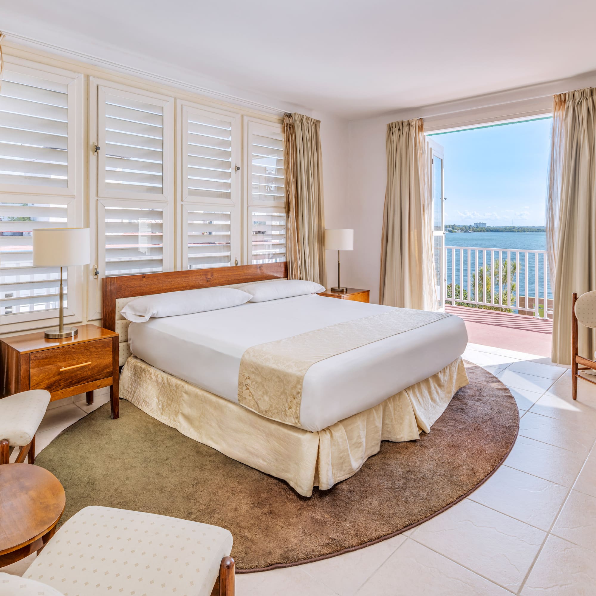 a bedroom with a large bed and chairs