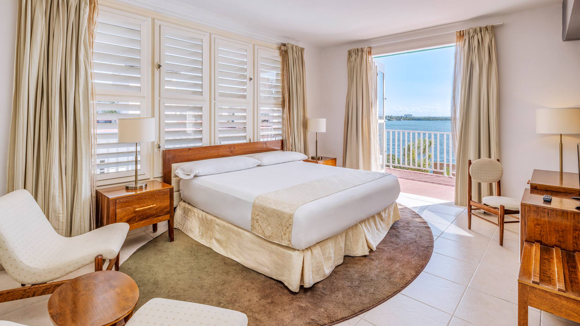 a bedroom with a large bed and chairs