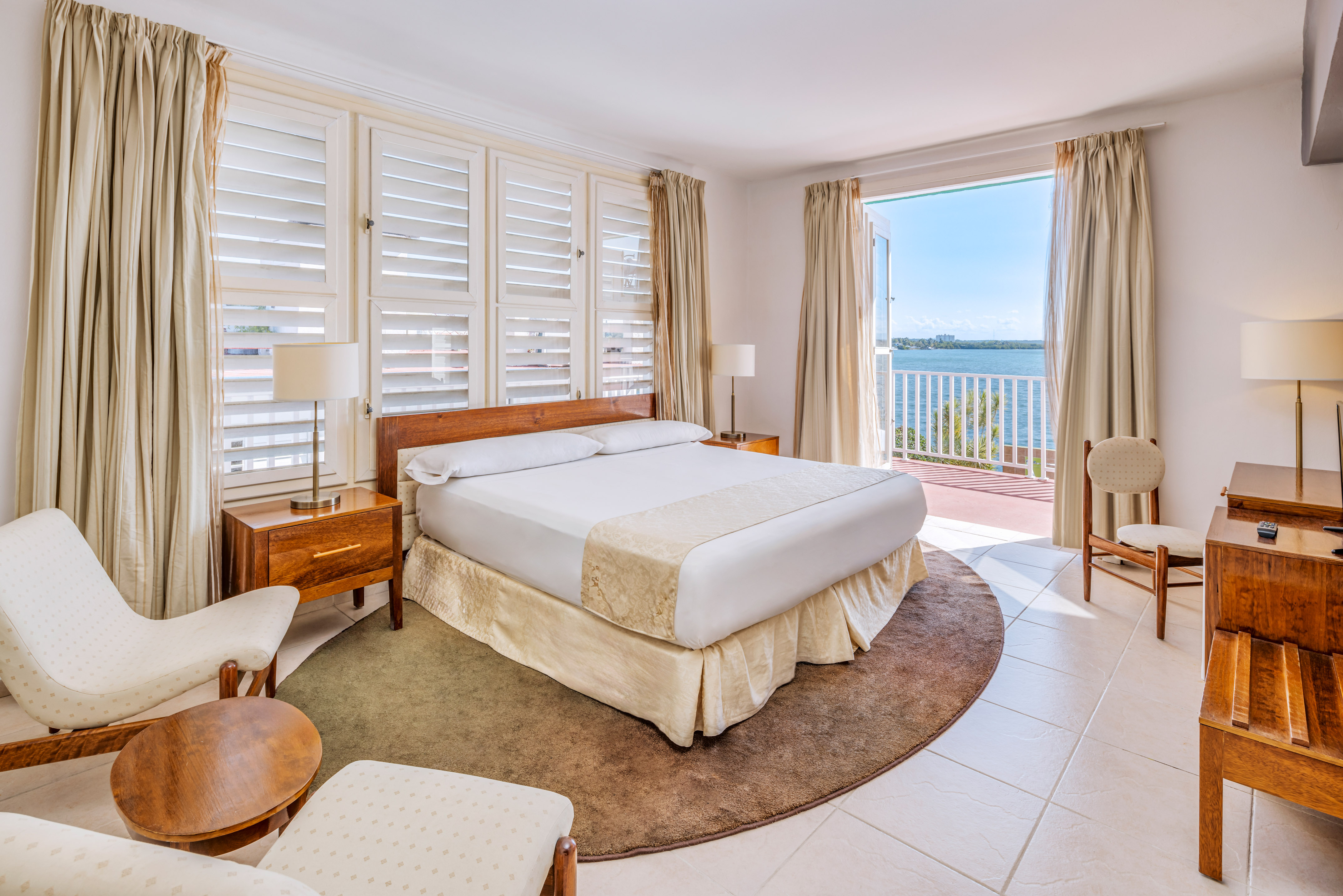 a bedroom with a large bed and chairs