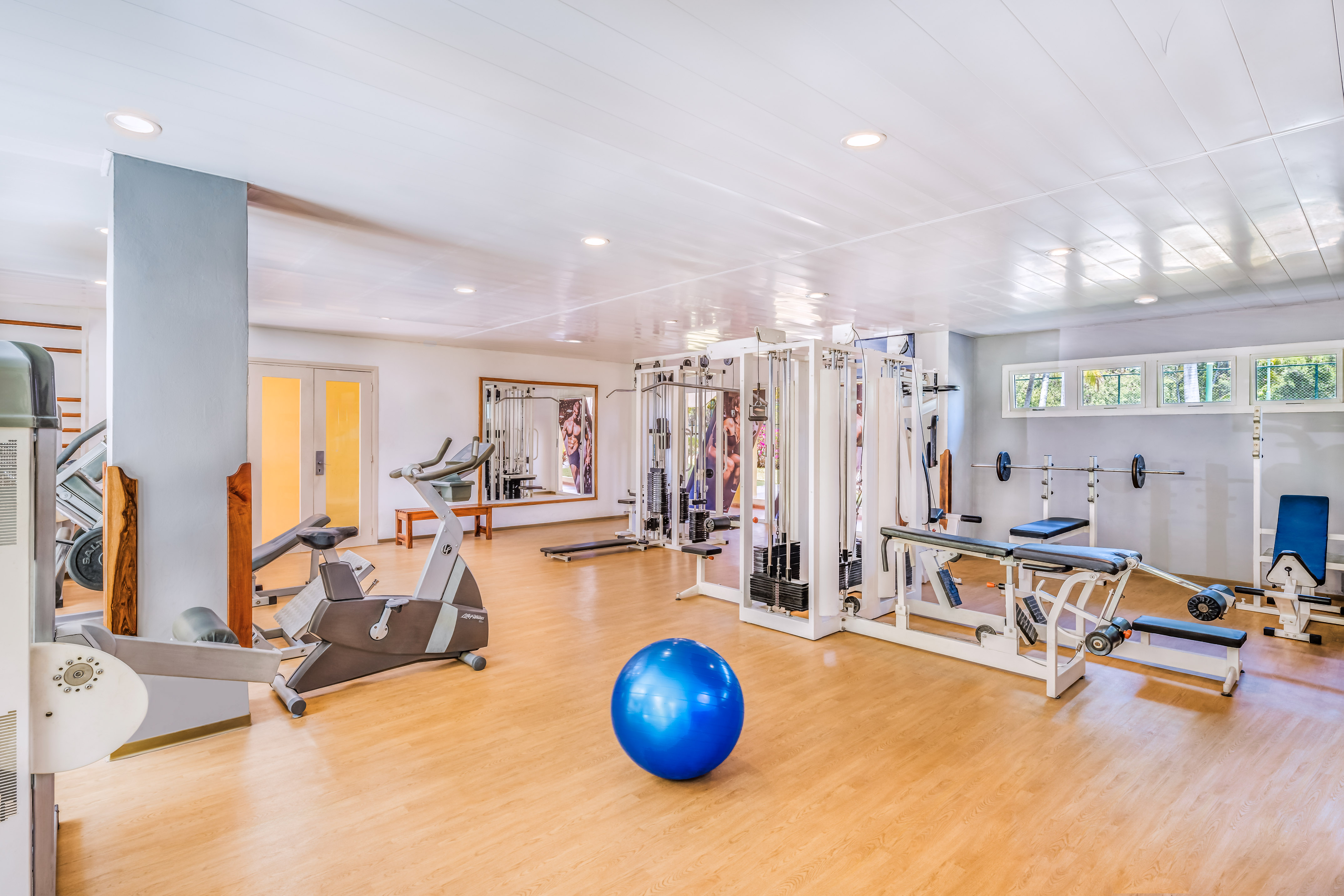a large room with exercise equipment and a blue ball