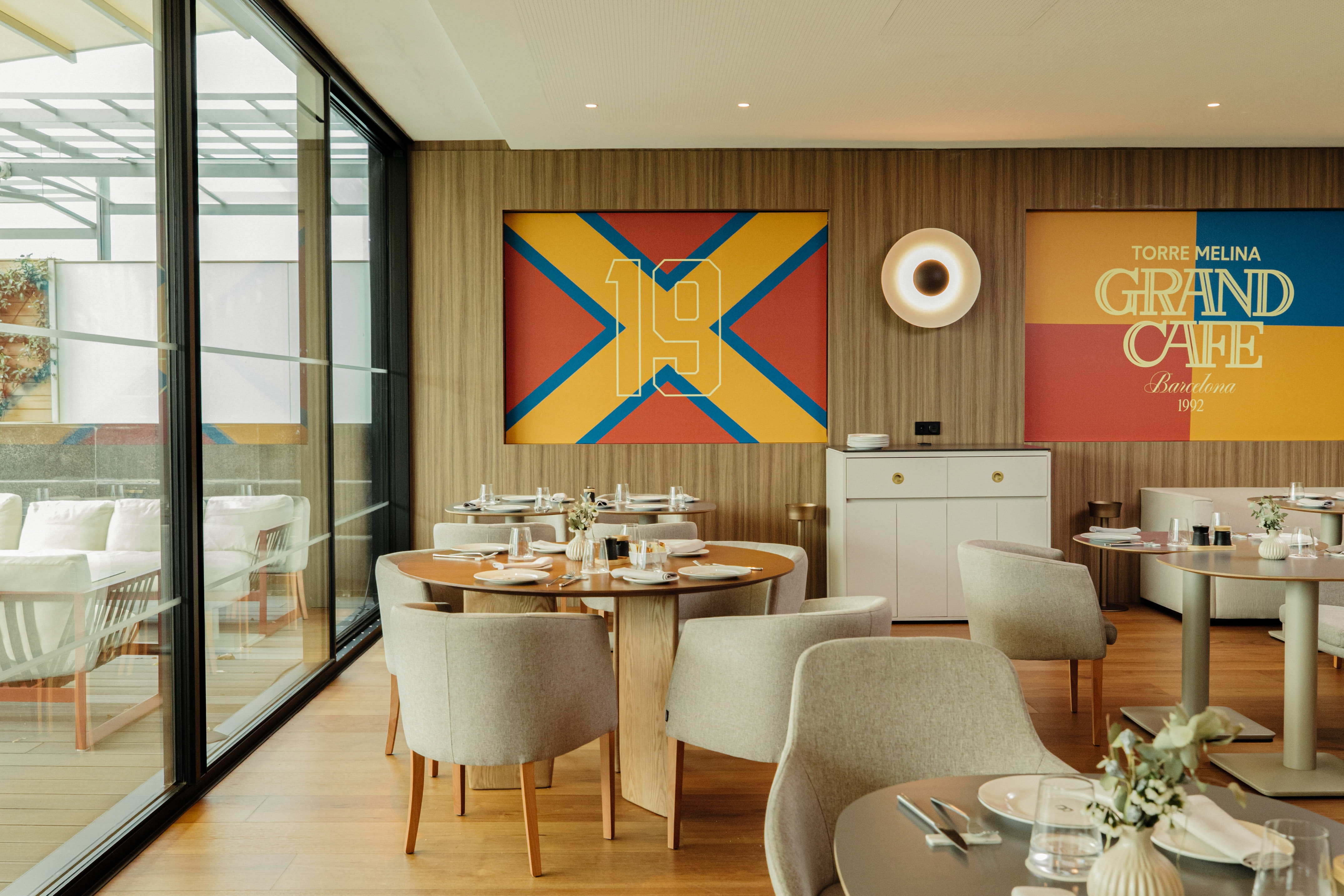 Modern Grand Cafe Barcelona dining room with set tables and large windows.