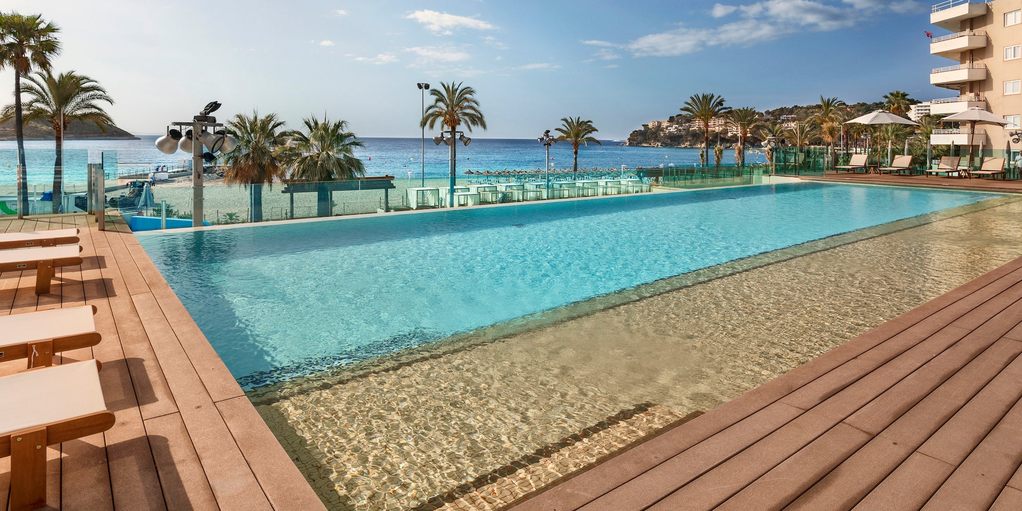 a pool with a deck and palm trees