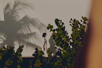 a woman standing on a ledge with leaves