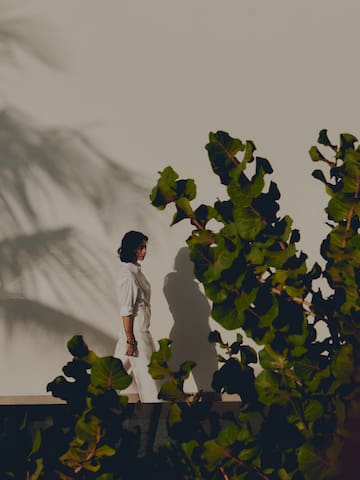 a woman standing on a ledge with leaves