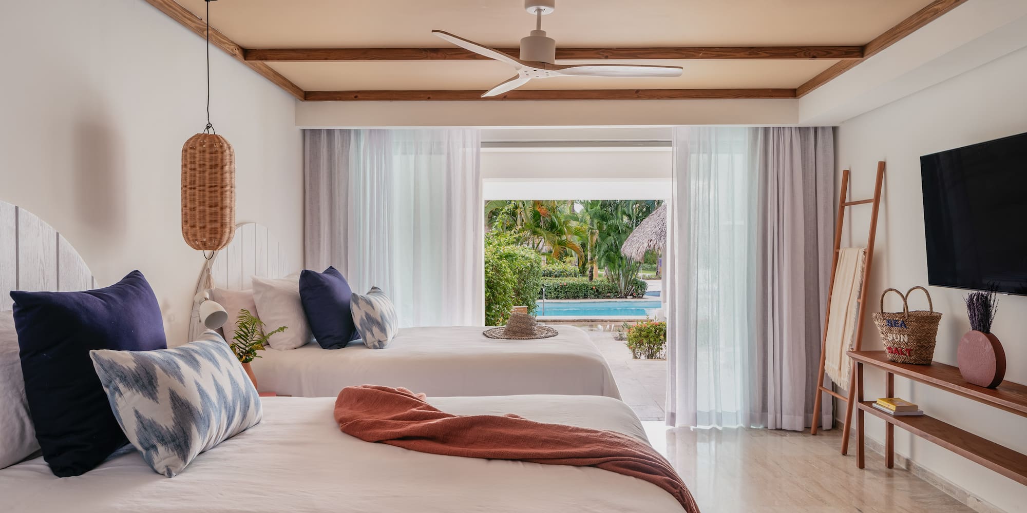 a room with two beds and a pool in the background