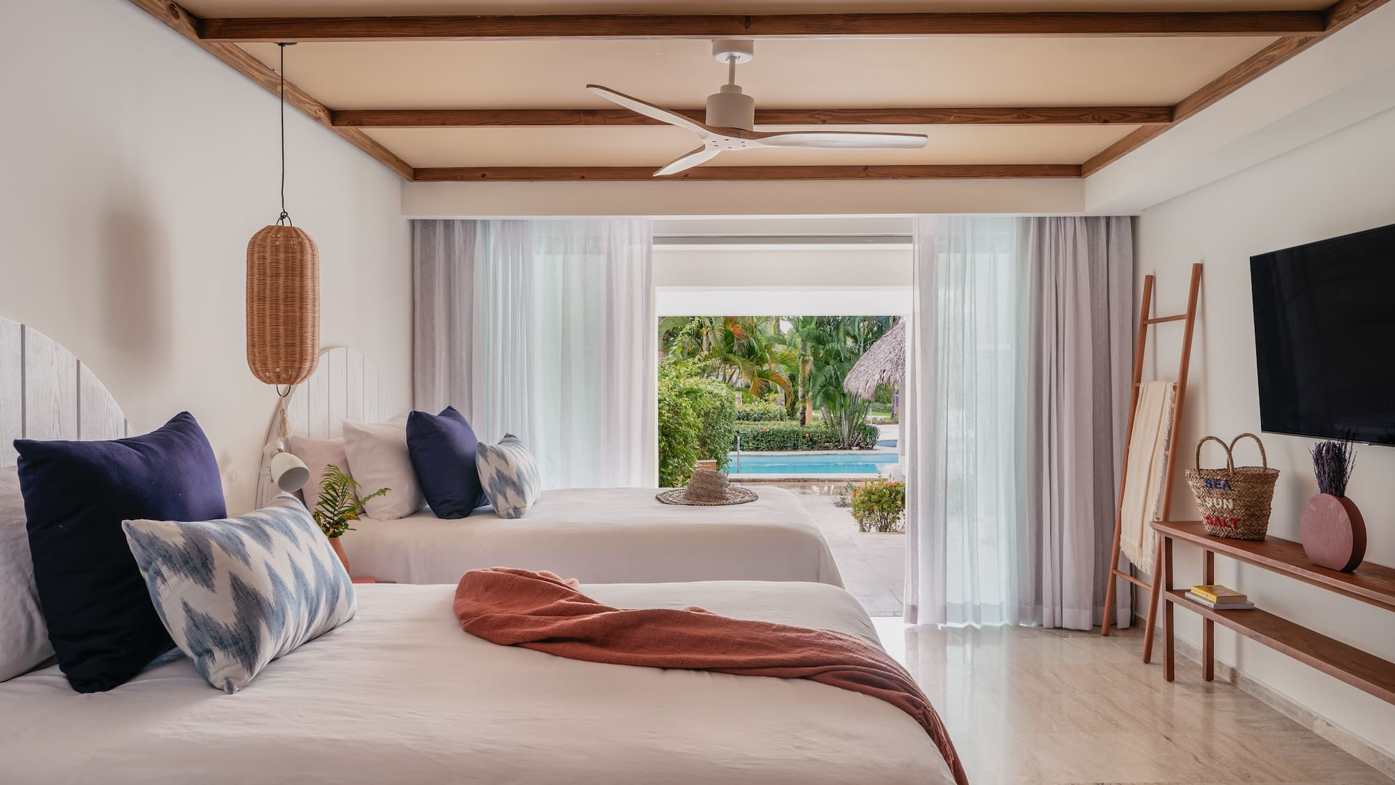a room with two beds and a pool in the background