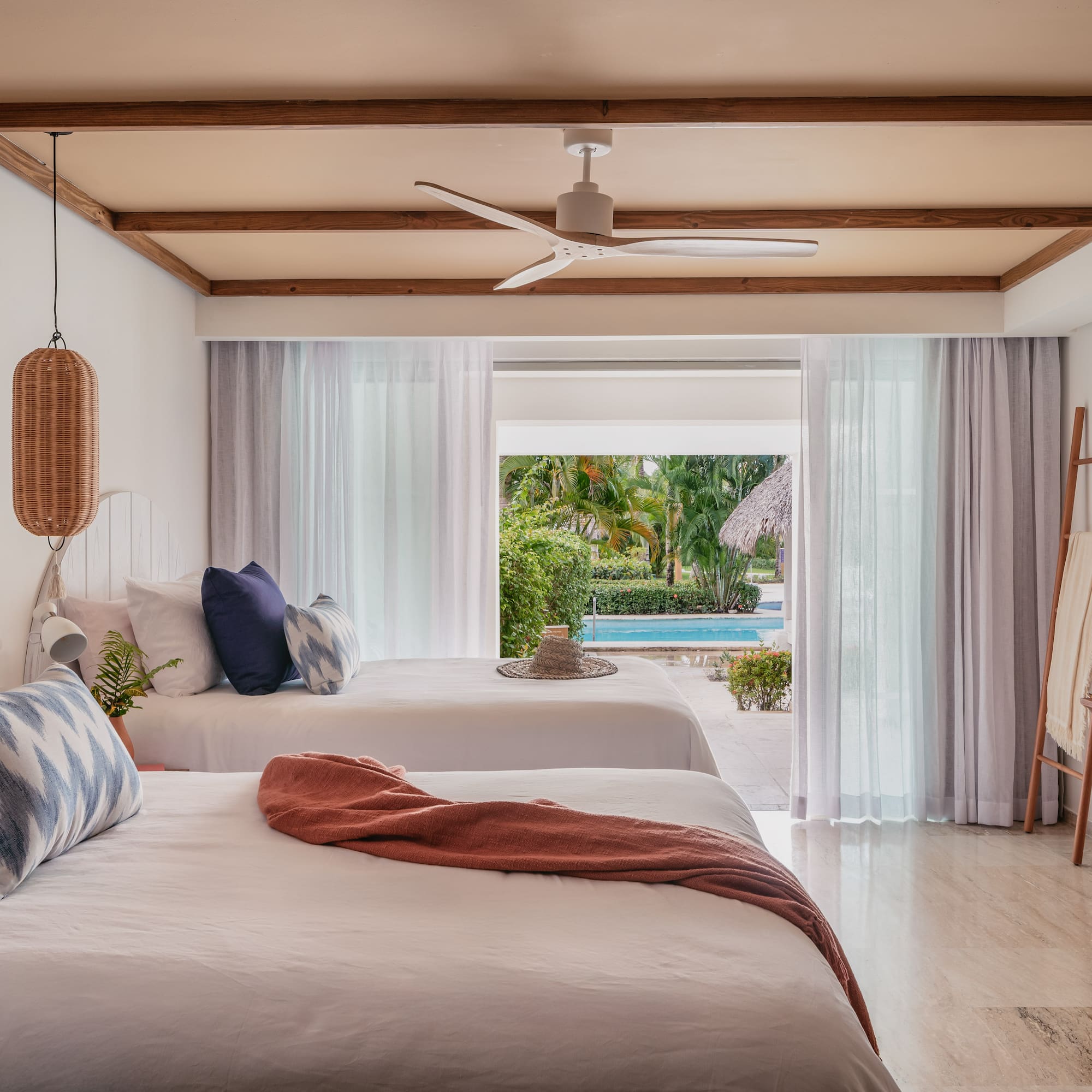 a room with two beds and a pool in the background