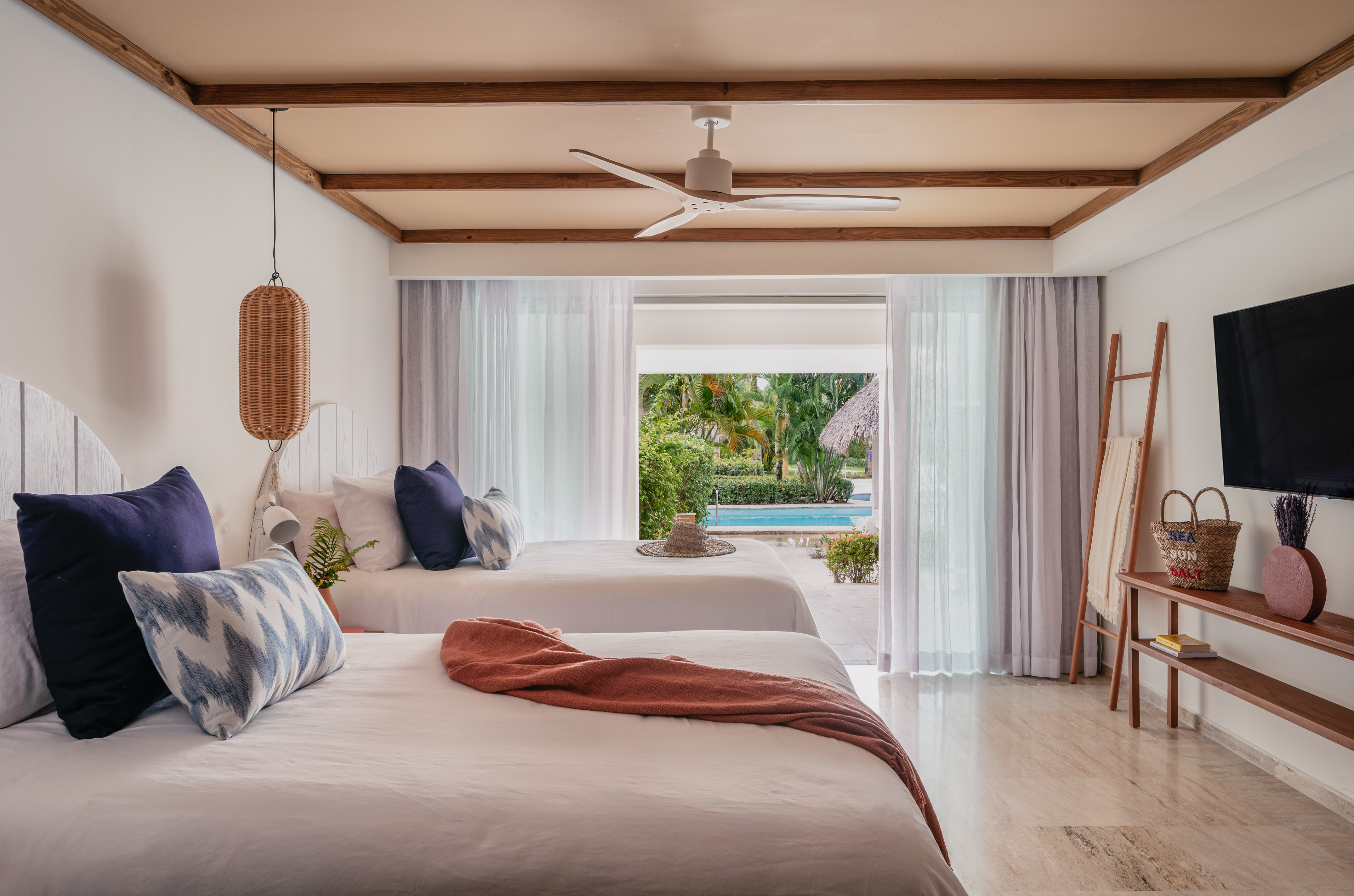 a room with two beds and a pool in the background