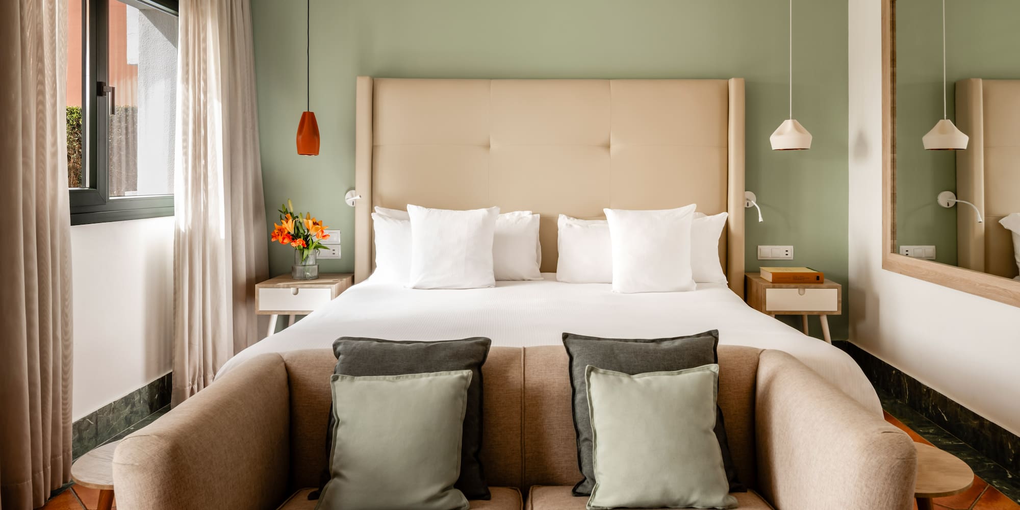 a bed with pillows and a couch in a room