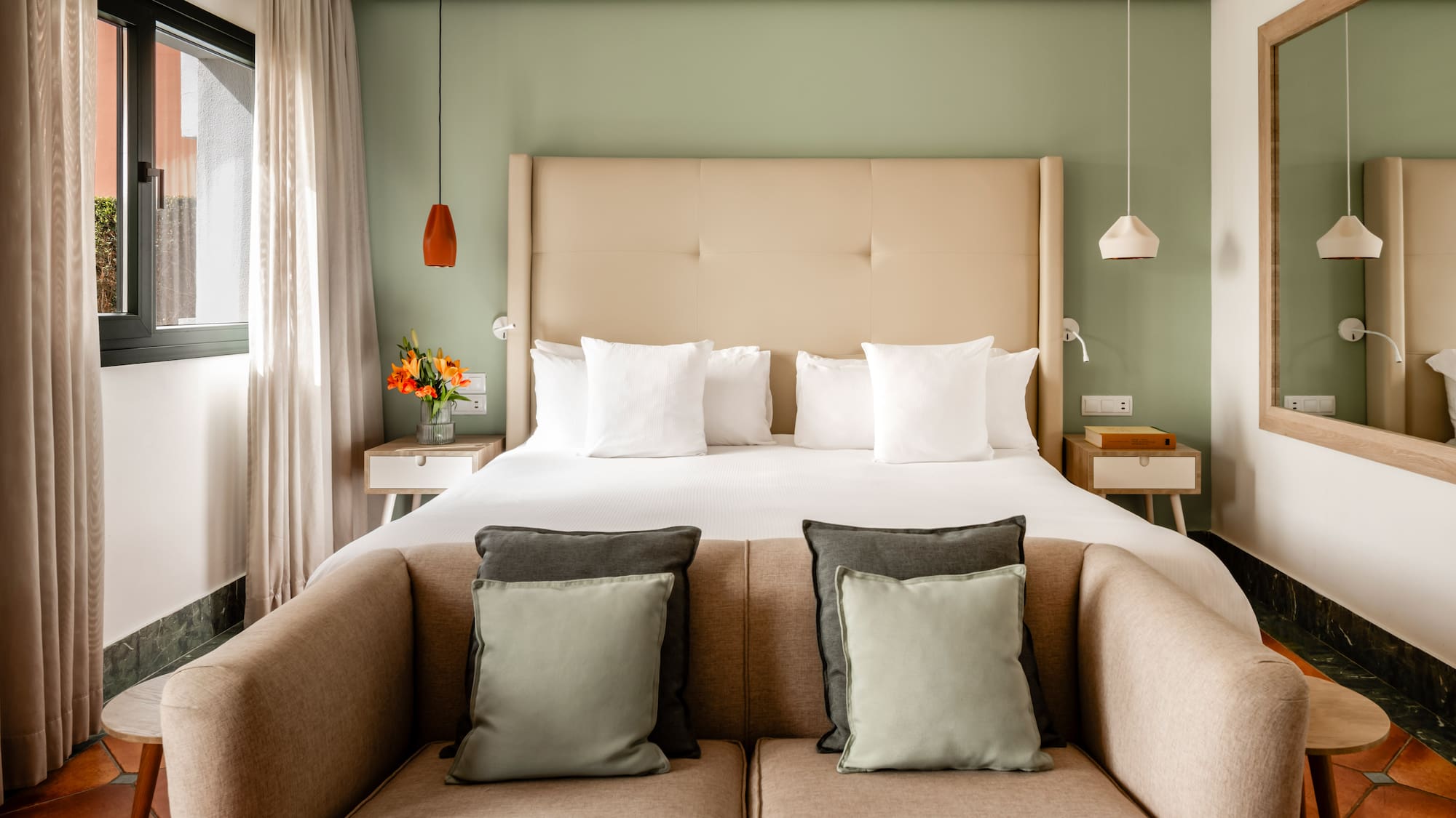 a bed with pillows and a couch in a room