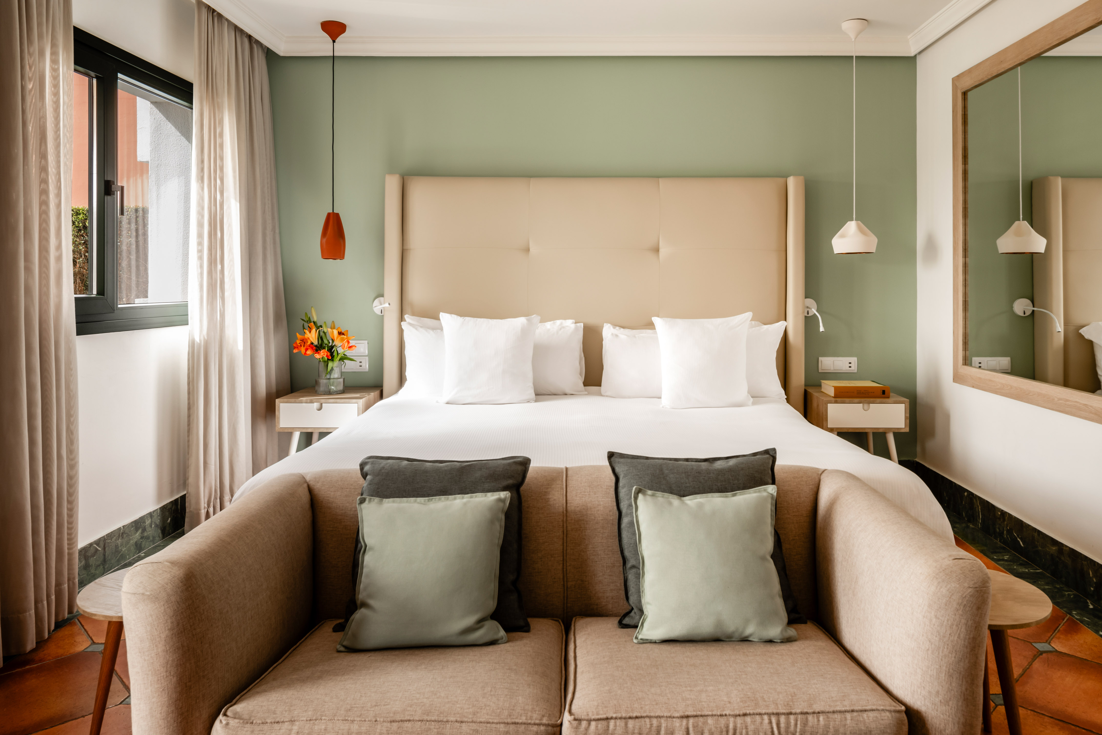 a bed with pillows and a couch in a room