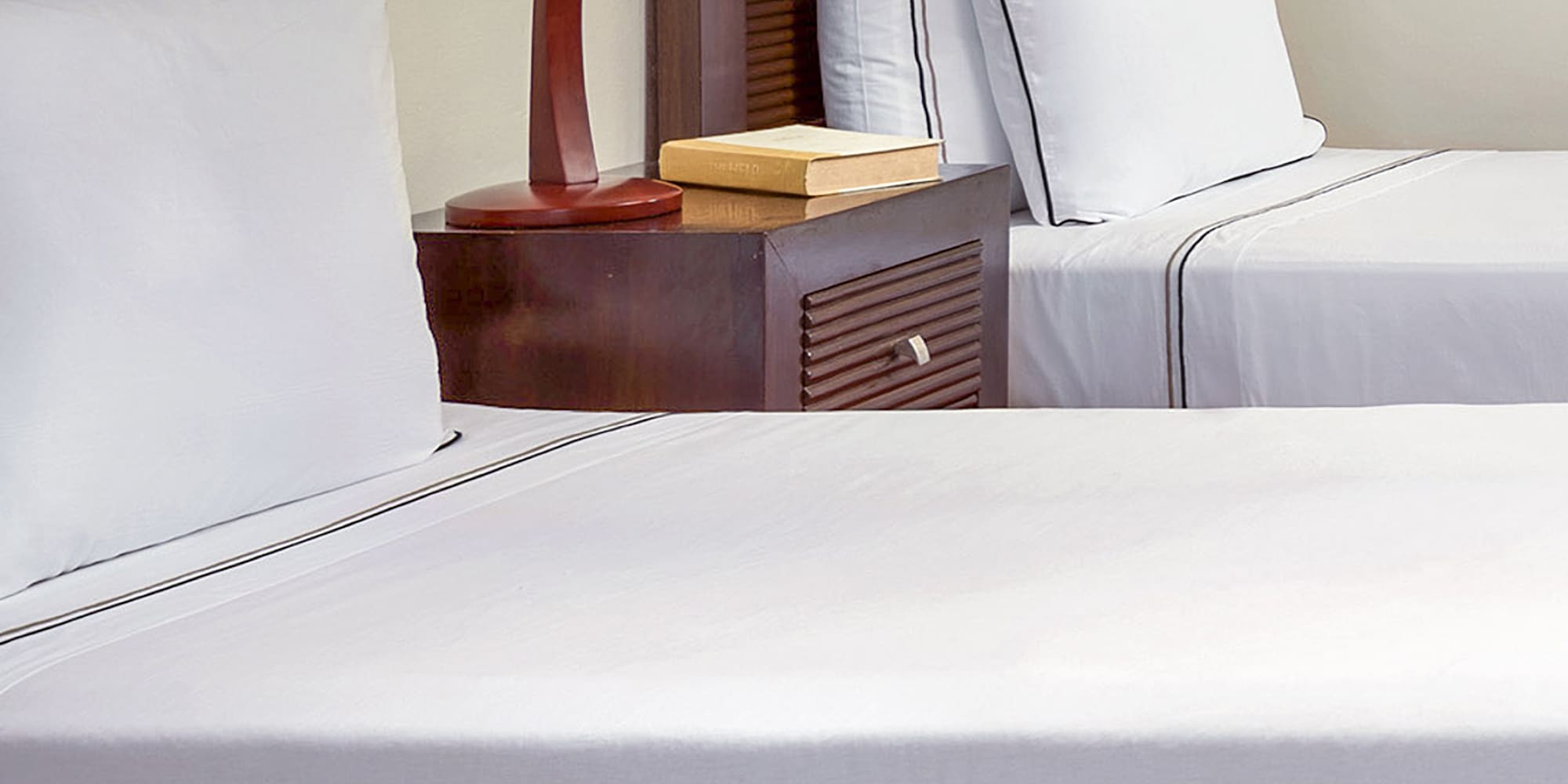 a bed with white sheets and a lamp