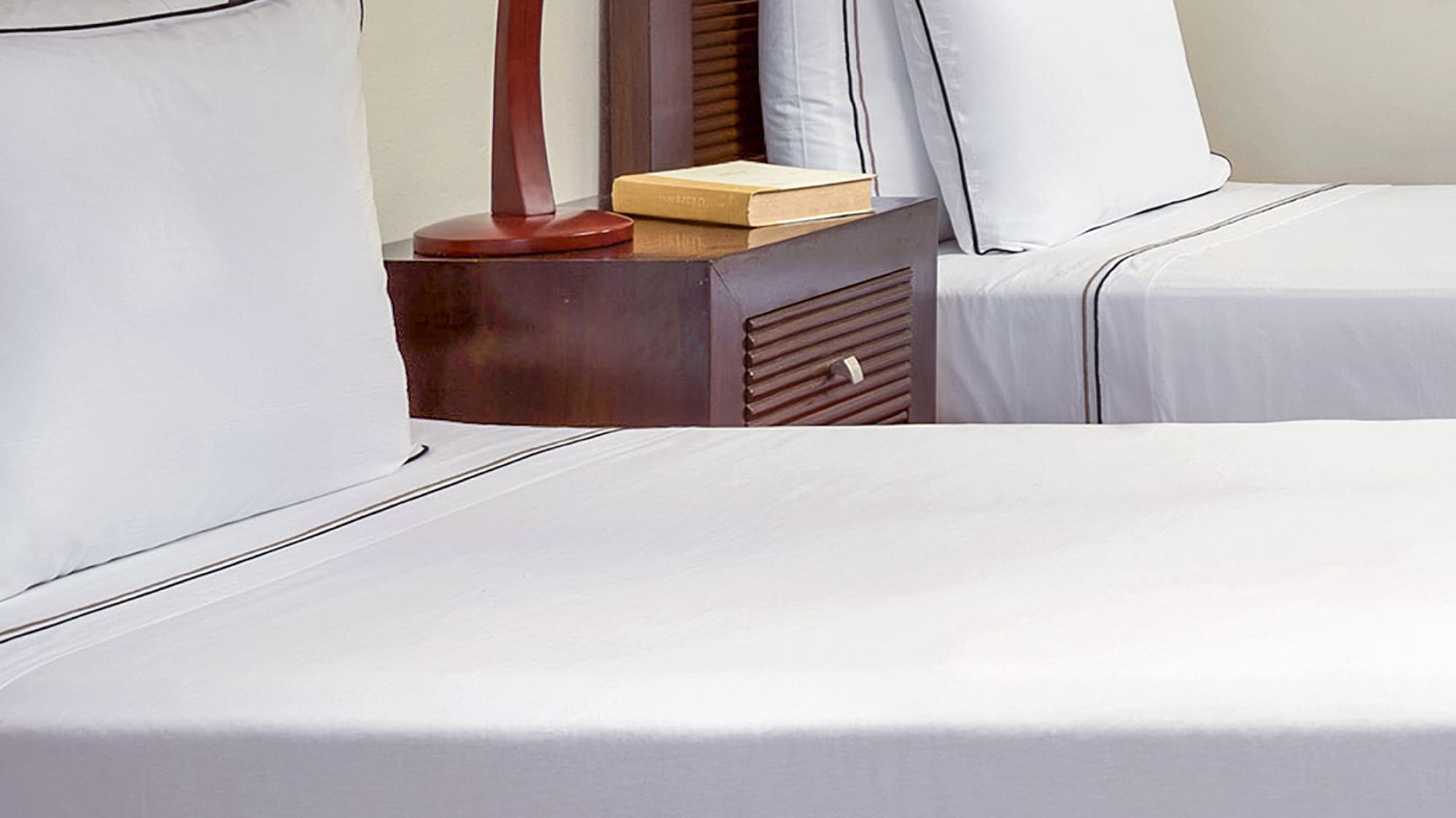 a bed with white sheets and a lamp