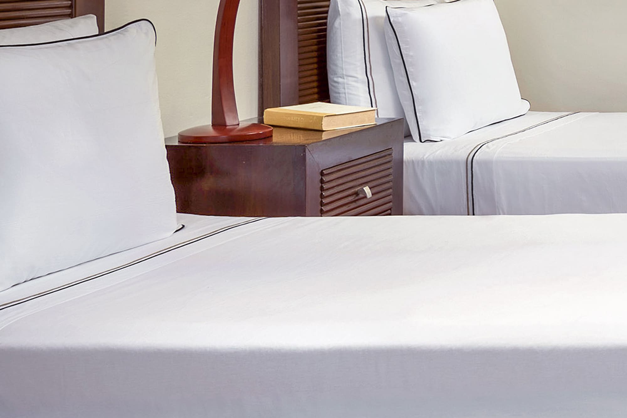 a bed with white sheets and a lamp