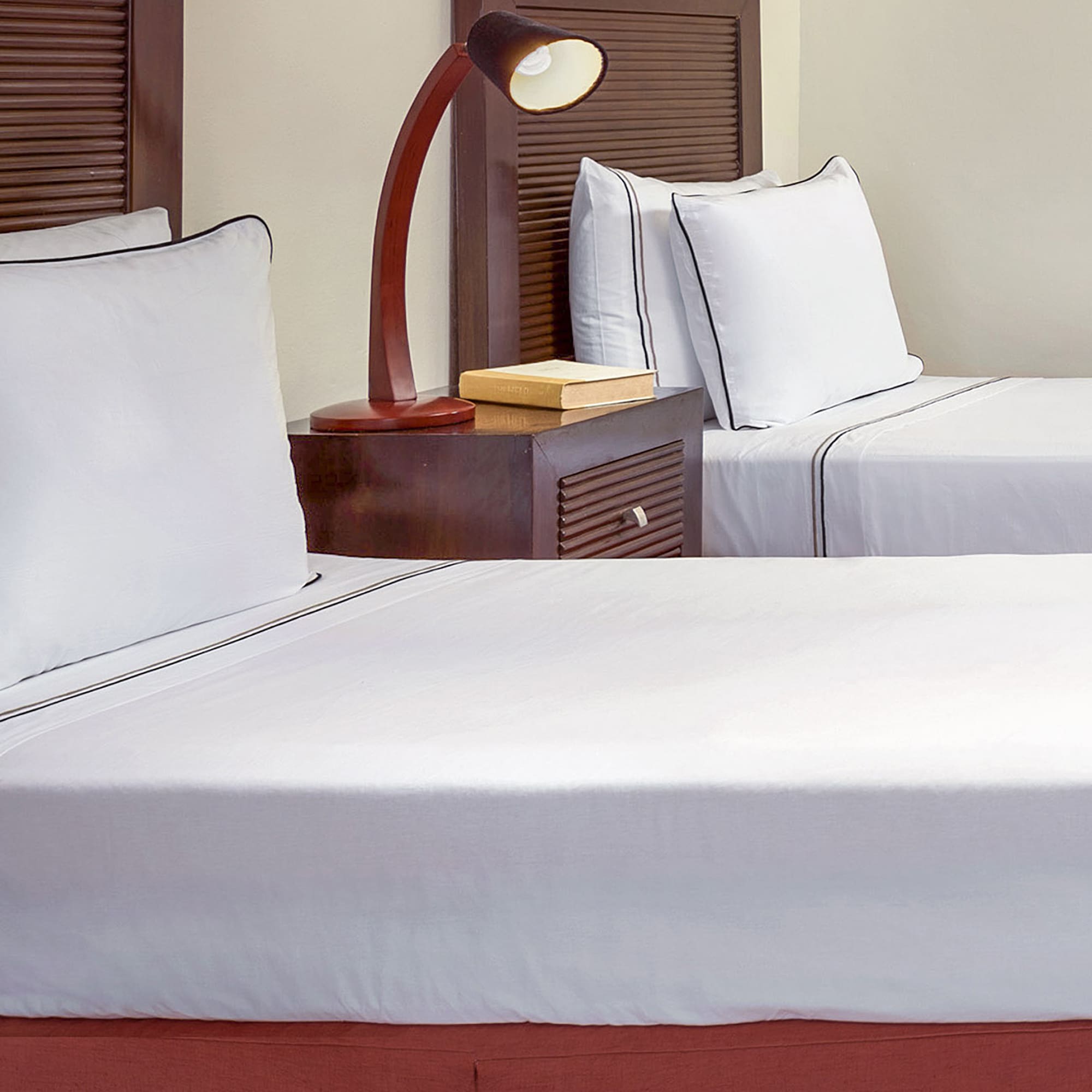 a bed with white sheets and a lamp