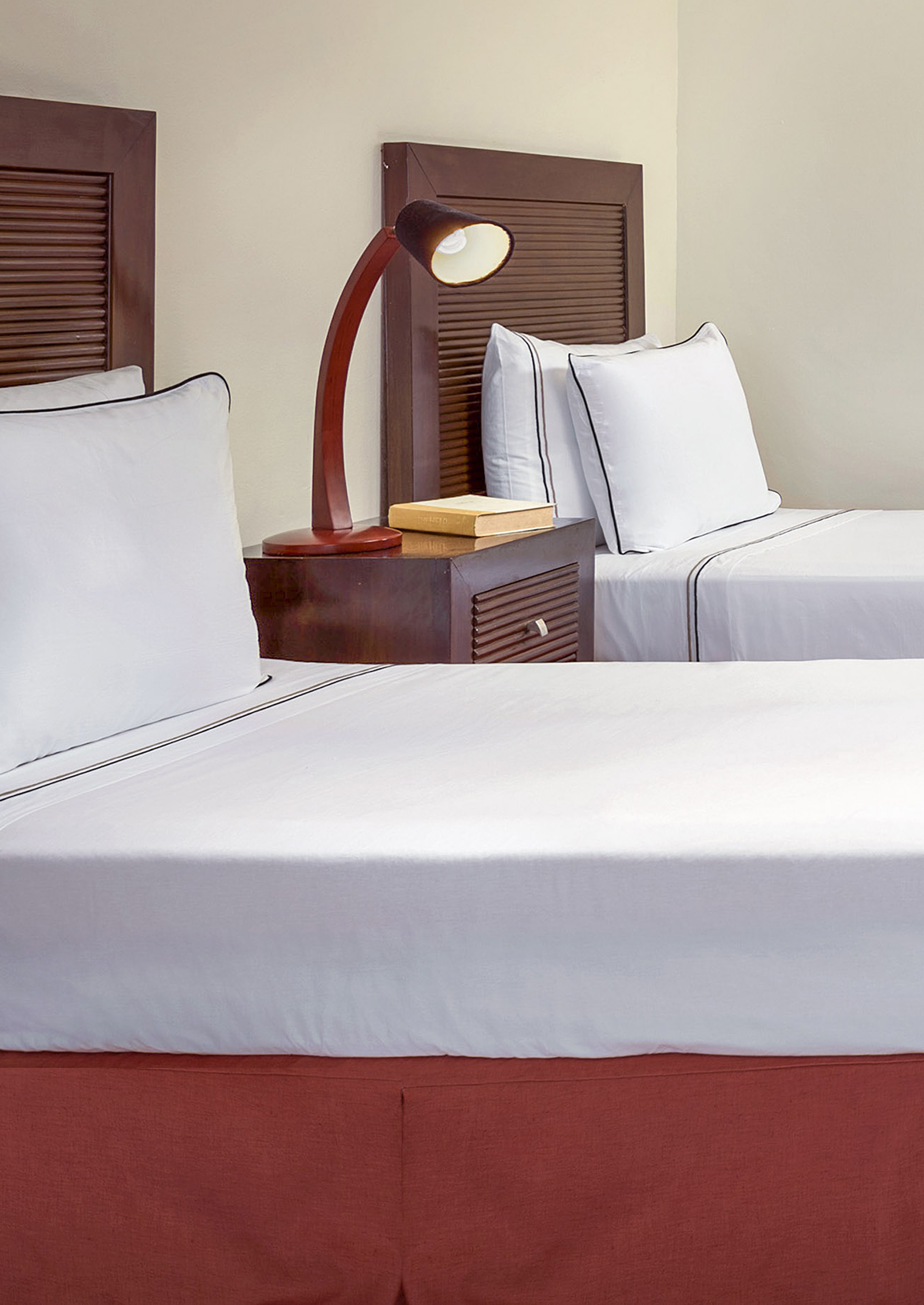 a bed with white sheets and a lamp