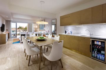 a dining table and kitchen with wood cabinets
